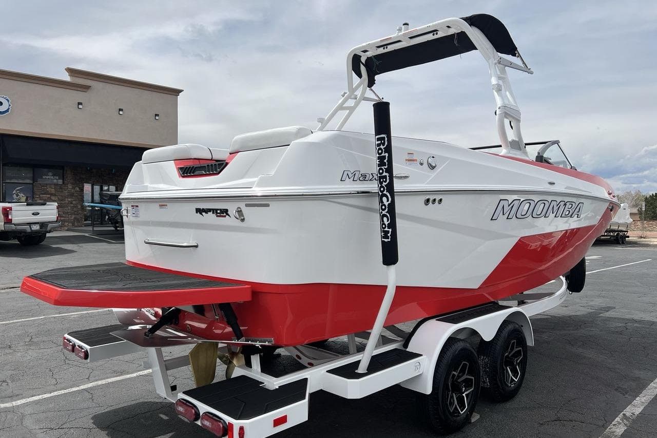 2025 Moomba Max boat on trailer, white and red design, parked outdoors.