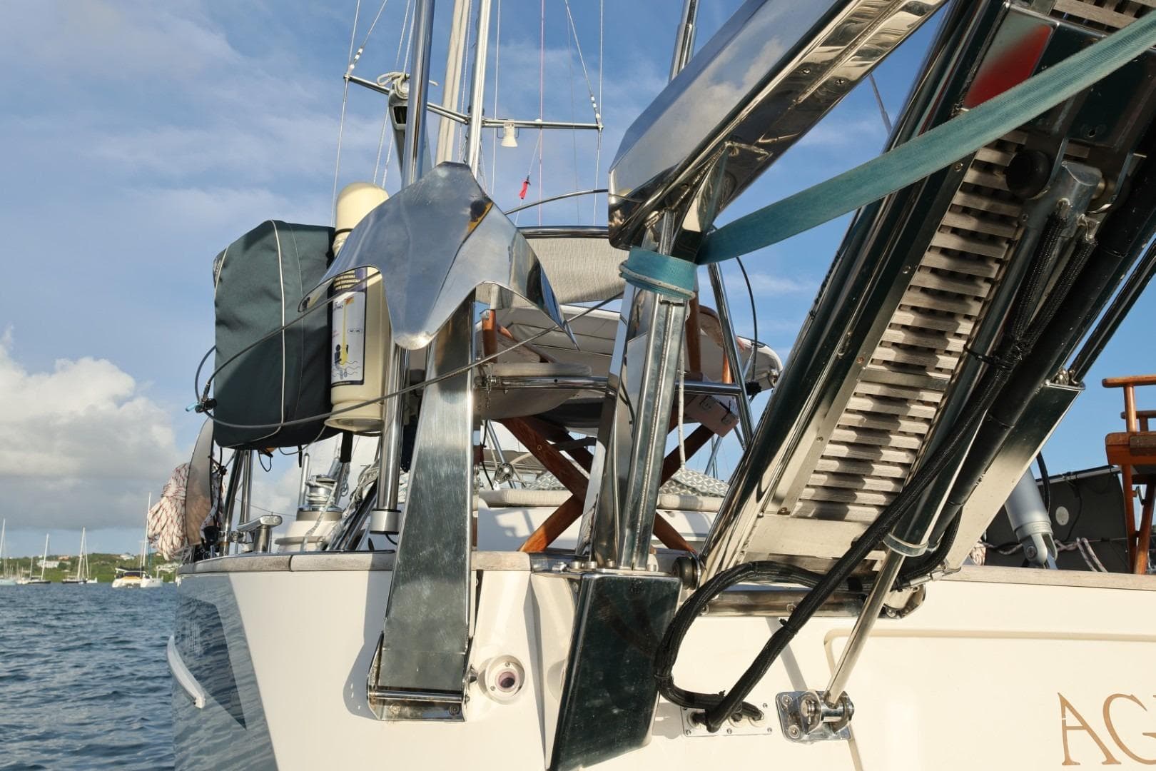 2009 Hallberg-Rassy 54 yacht with anchor and boarding ladder, docked in a serene harbor.