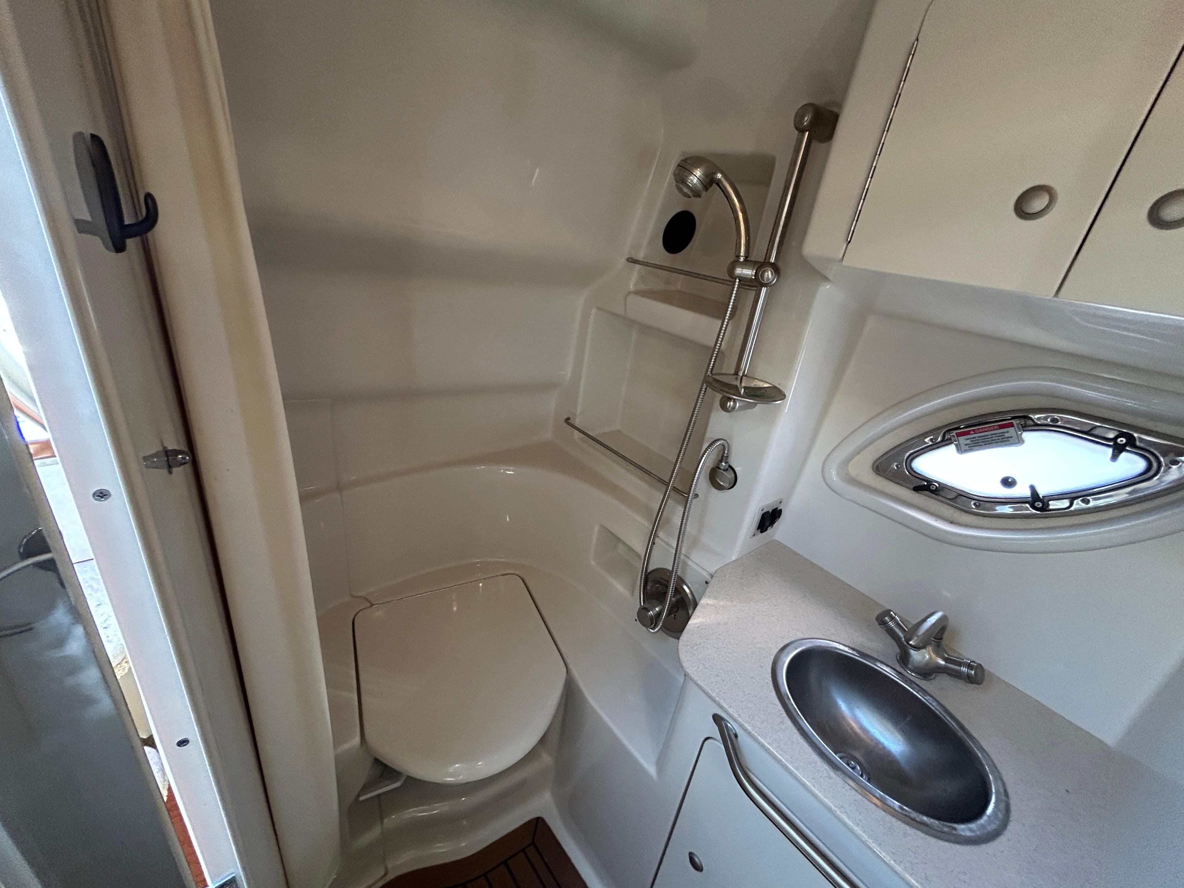 2008 Sea Ray 330 Sundancer bathroom with toilet, sink, and showerhead.