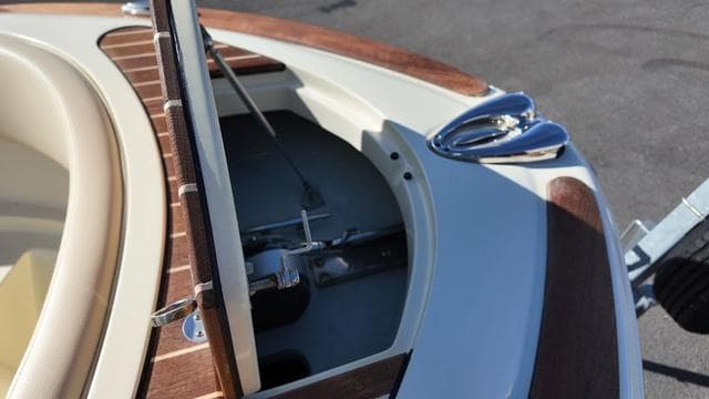 2017 Chris-Craft Launch 27 boat with open storage compartment and polished chrome details.