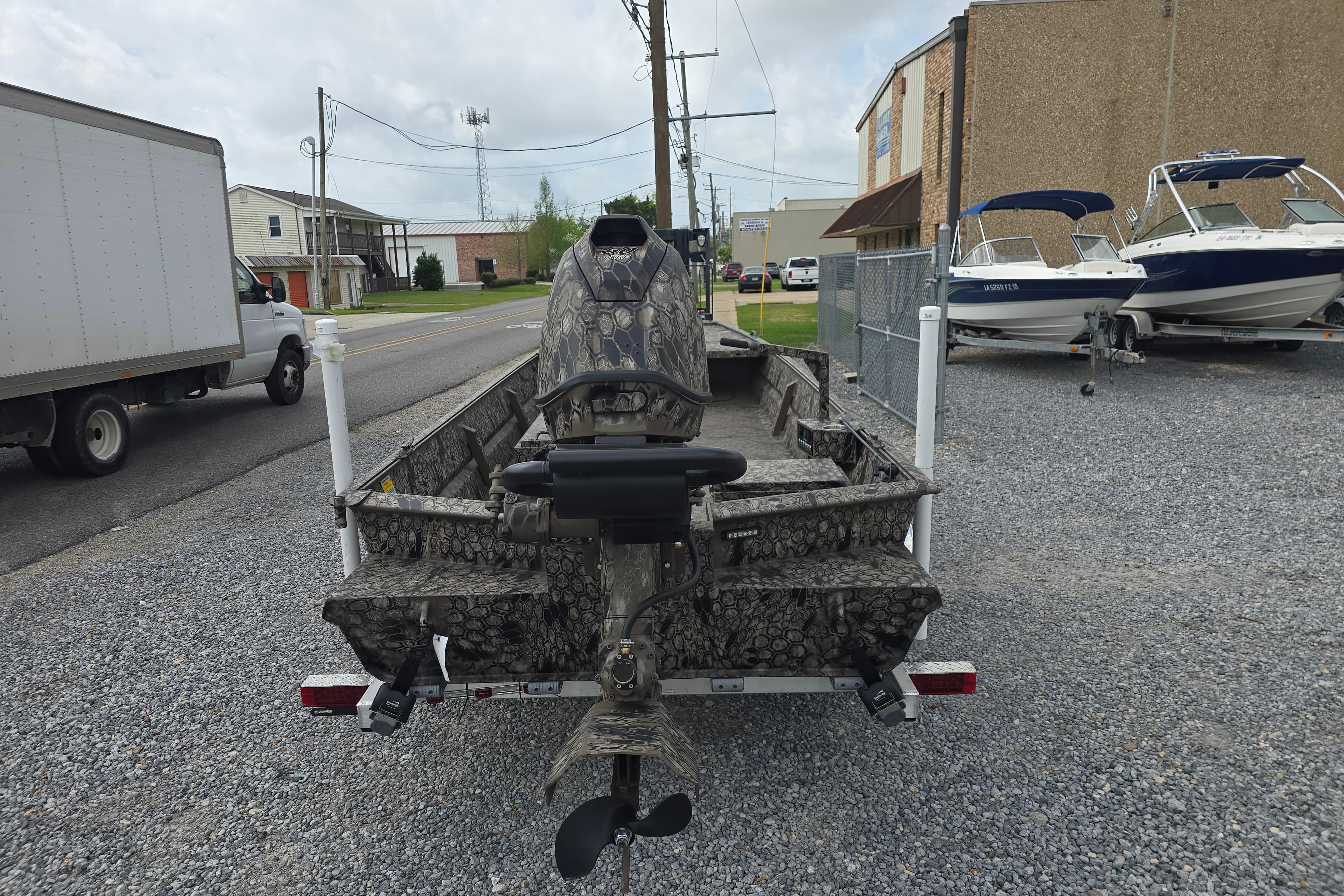 Pro-Drive 2060 boat, 2026 model, camo design, parked on gravel near other boats.