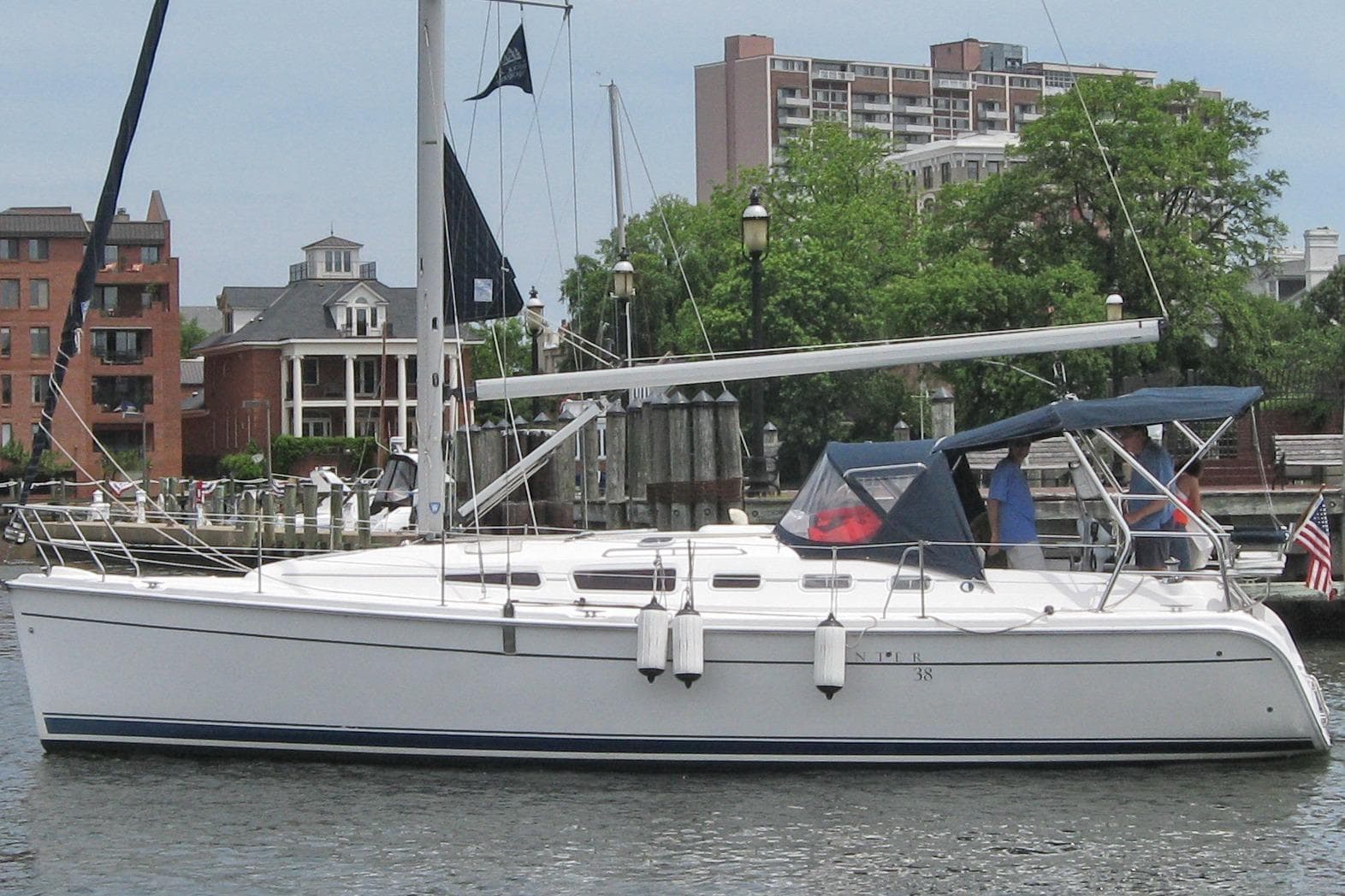 2006 Hunter 38 sailboat docked in a marina with urban buildings in the background.