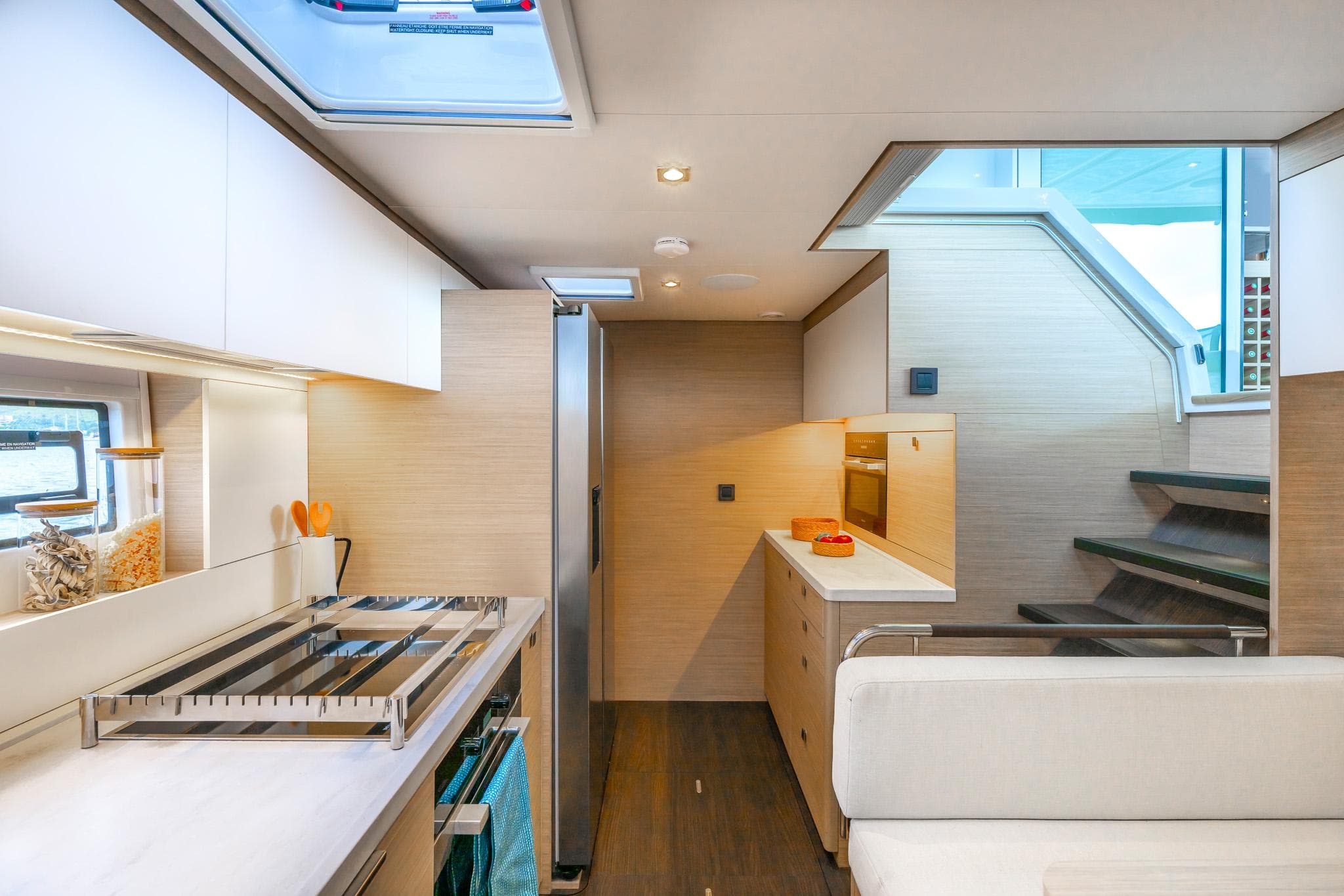 Modern kitchen interior of 2025 Lagoon 60 yacht with sleek design and ample natural light.