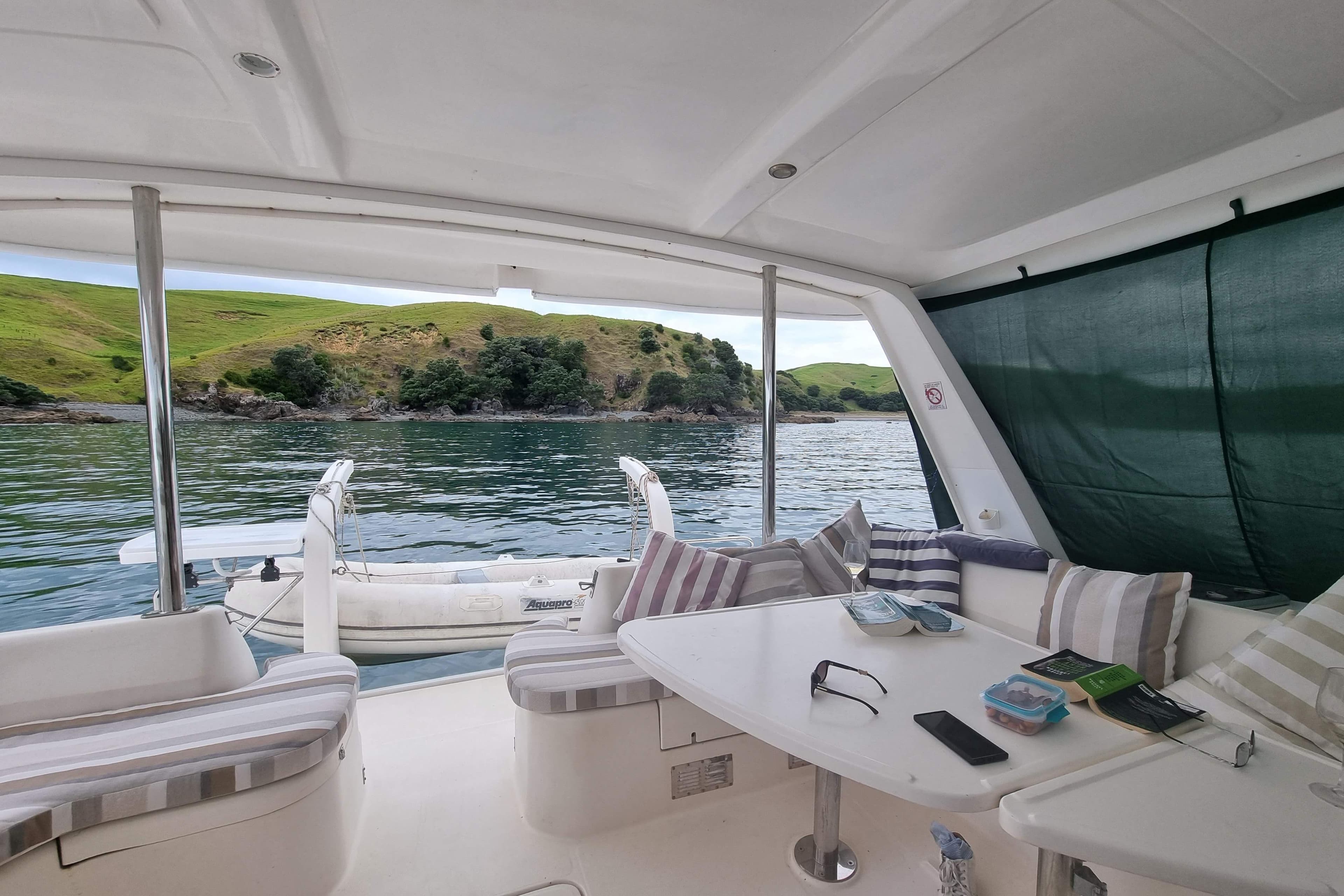 Leopard 43 yacht interior with scenic water view, featuring comfortable seating and a table.