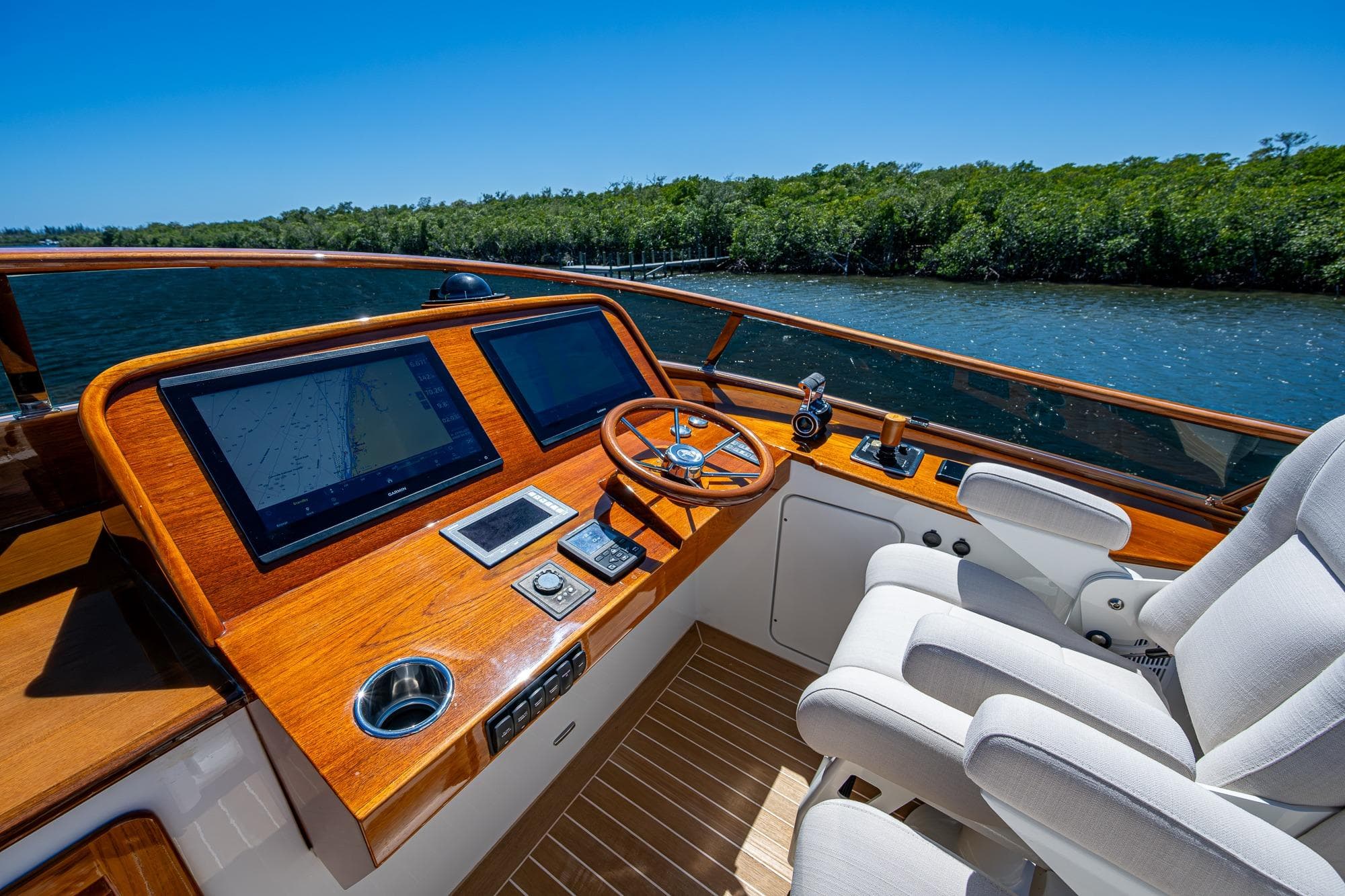 Helm of 2021 Hinckley Talaria yacht with dual screens and luxurious seating.