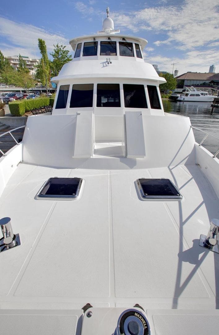 2027 Legend Boats 630 Skylounge yacht docked, showcasing sleek design and spacious deck.