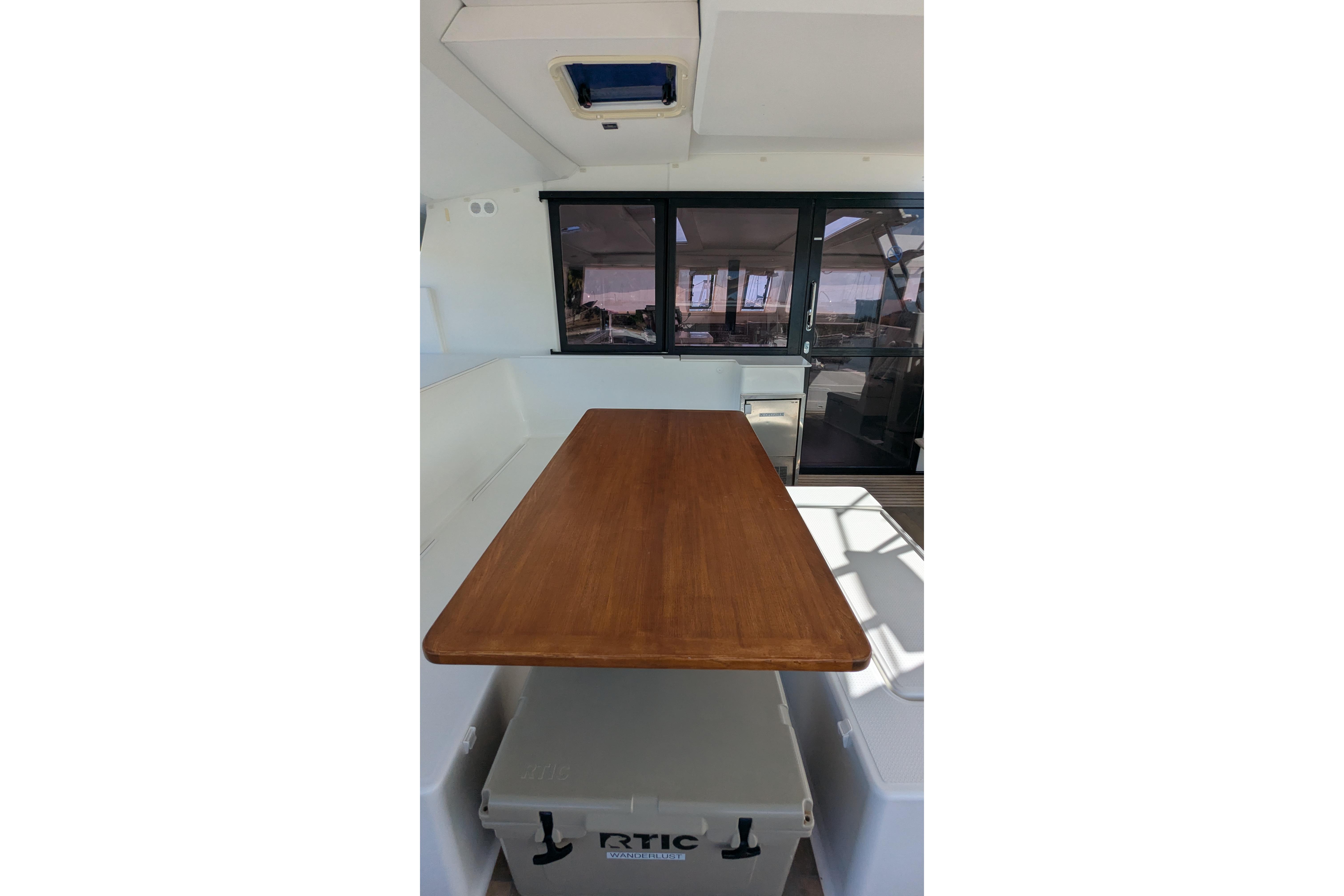 Interior of 2020 Fountaine Pajot Saona 47 catamaran with wooden table and seating area.