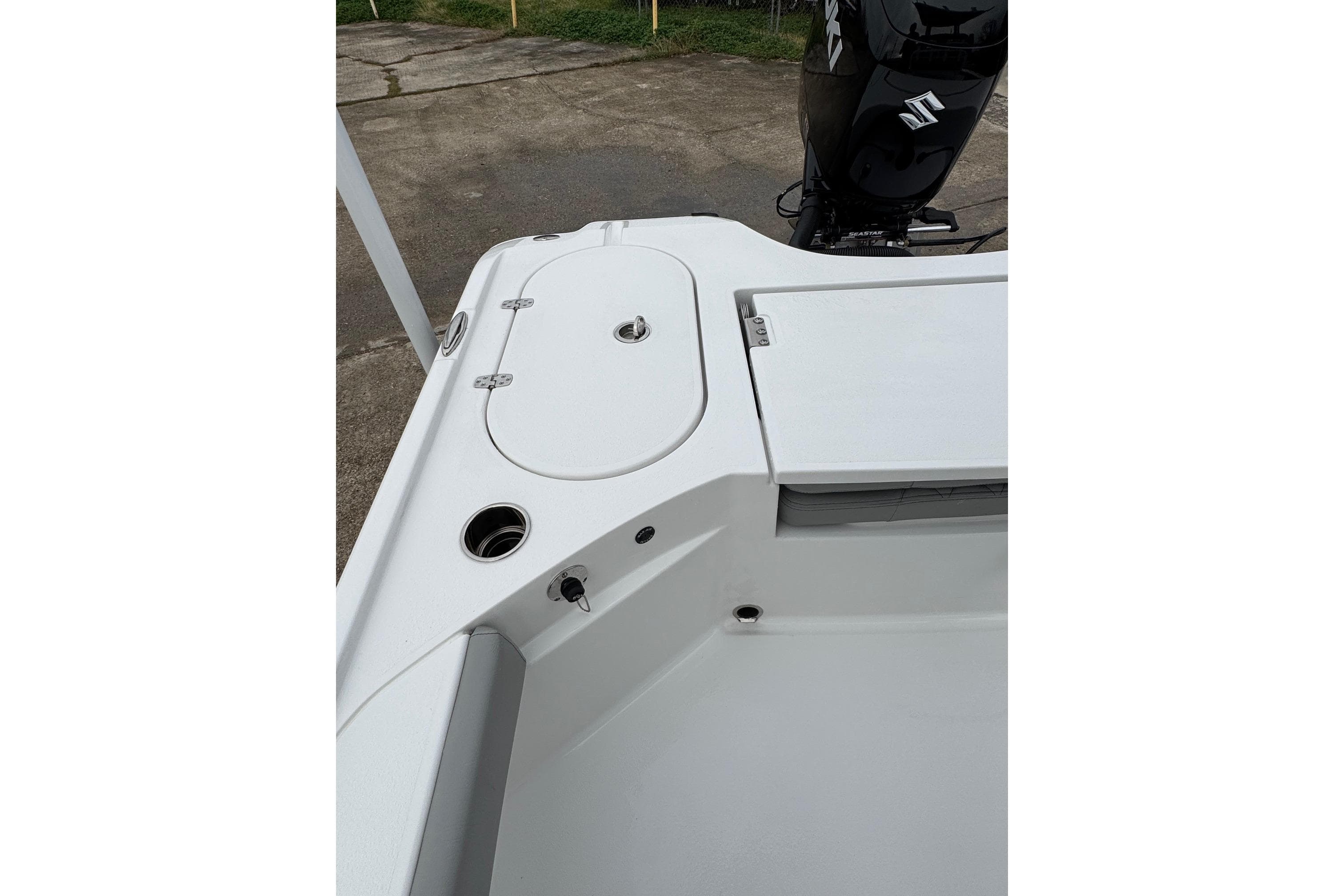 2026 Blazer Bay 2440 boat deck with storage compartments and motor.