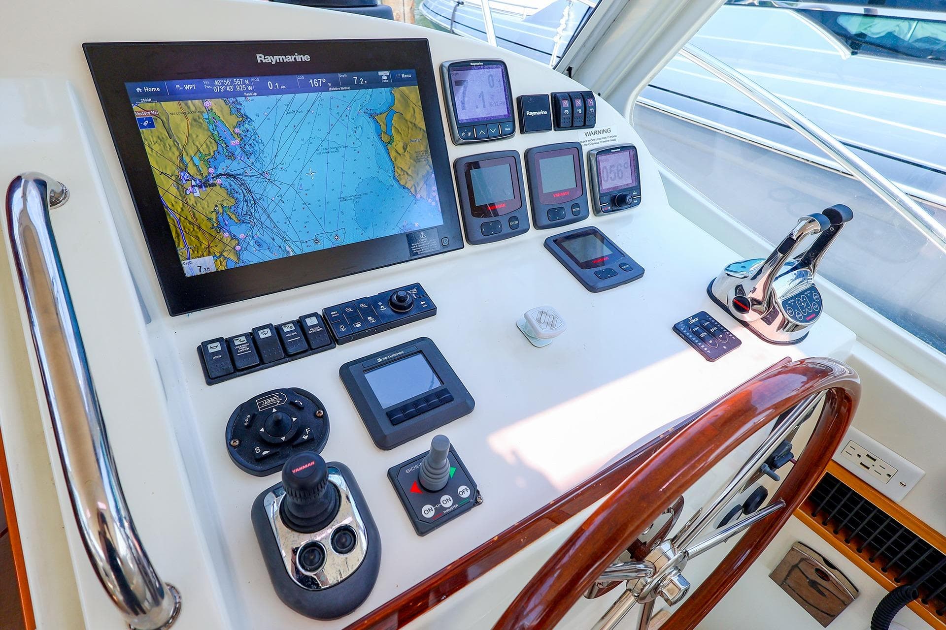 Helm of 2010 MJM 40z Downeast boat with navigation equipment and wooden steering wheel.