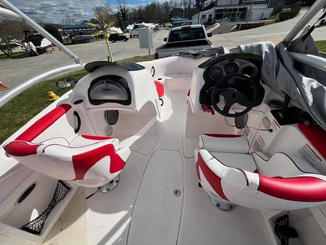 2004 Yamaha Boats AR 210 interior with red and white seating, dashboard, and steering wheel.