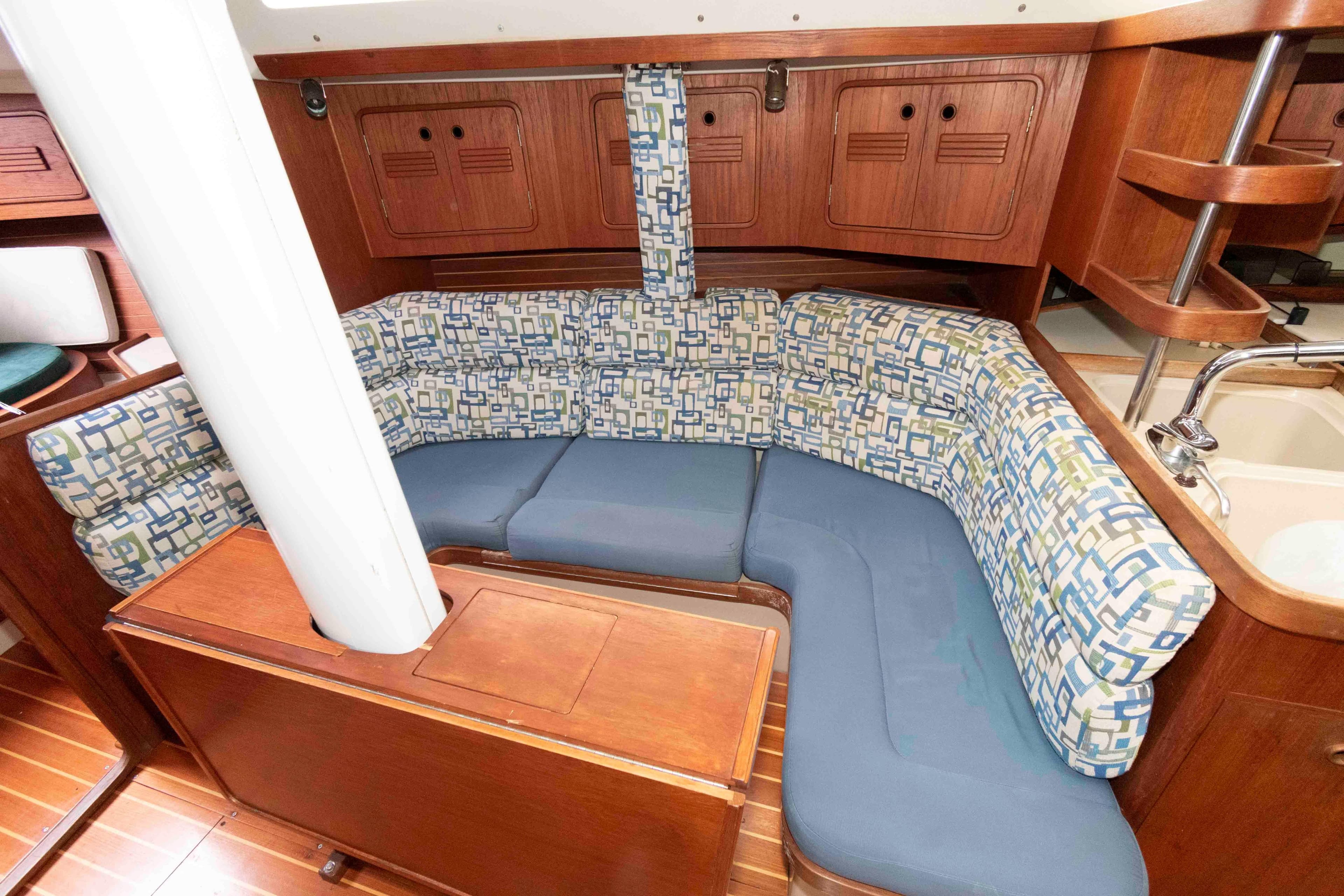 Interior of 1993 C&C 37/40 XL sailboat with patterned seating and wooden cabinetry.