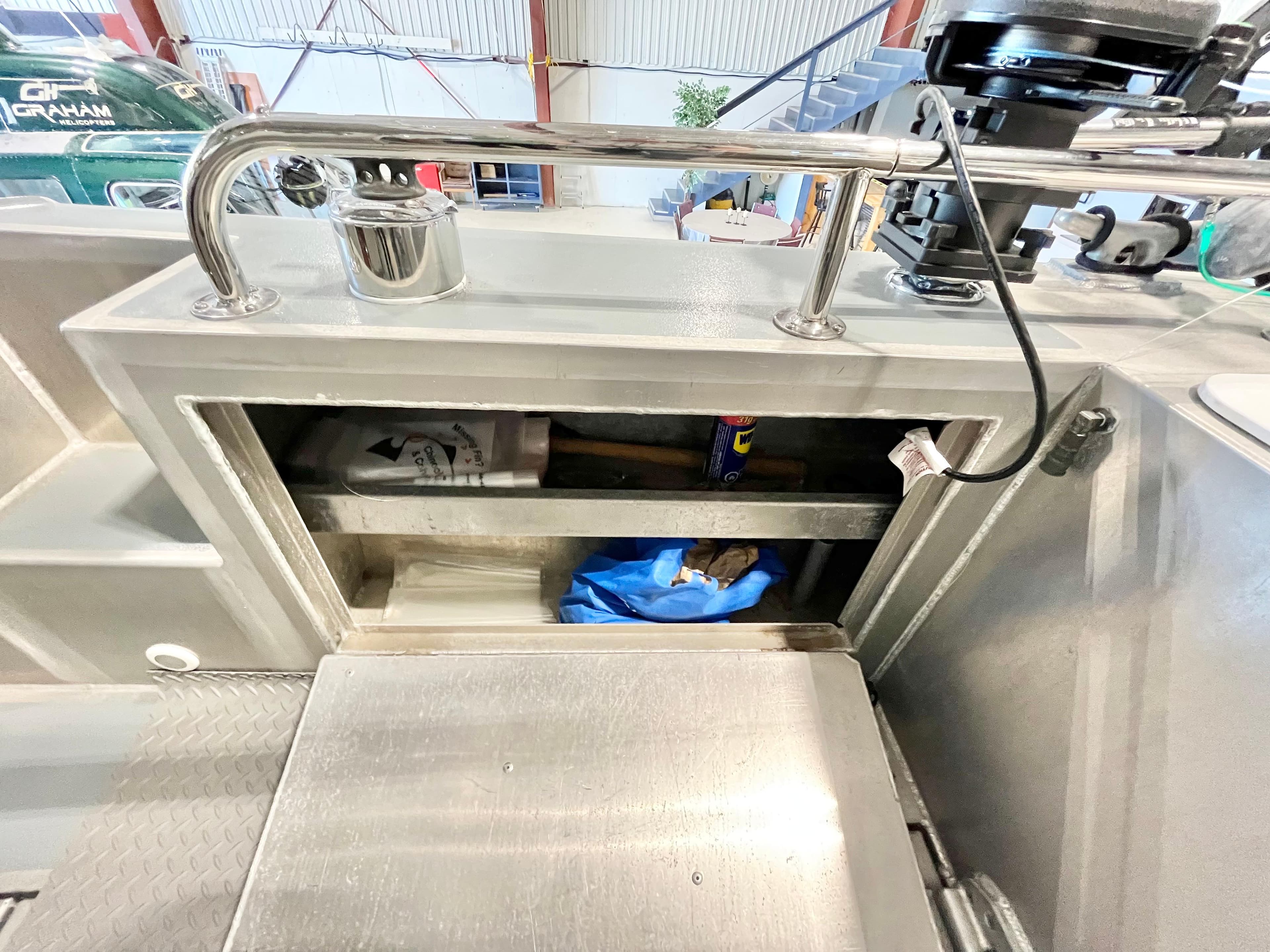 Storage compartment on a 2007 Coastal Craft 36 Cruiser boat, featuring tools and supplies.
