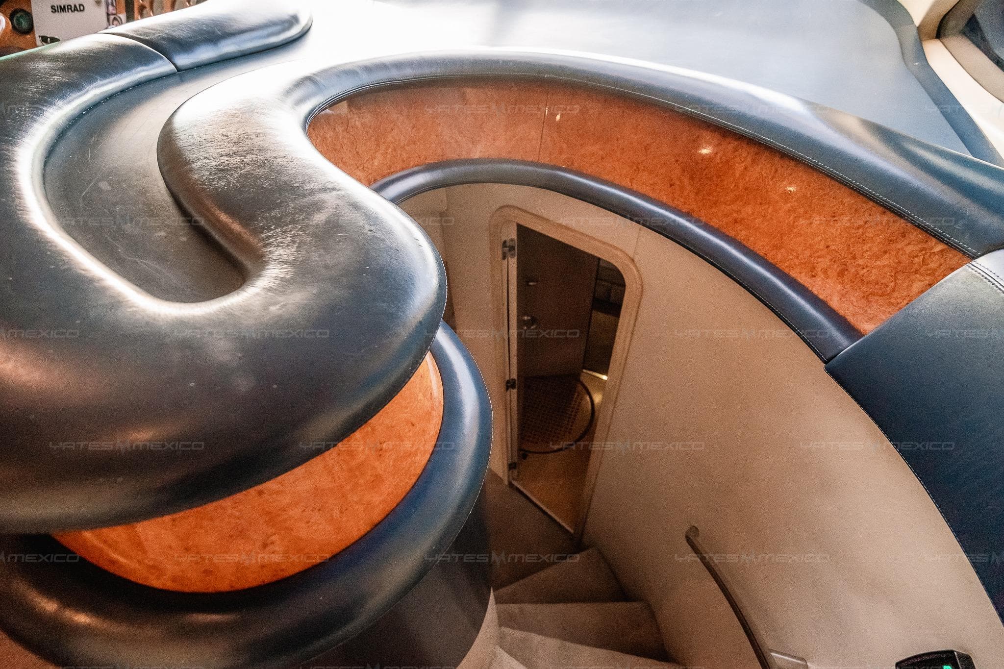 Curved staircase on 2004 Azimut 68 Plus yacht, featuring elegant wood and leather finishes.