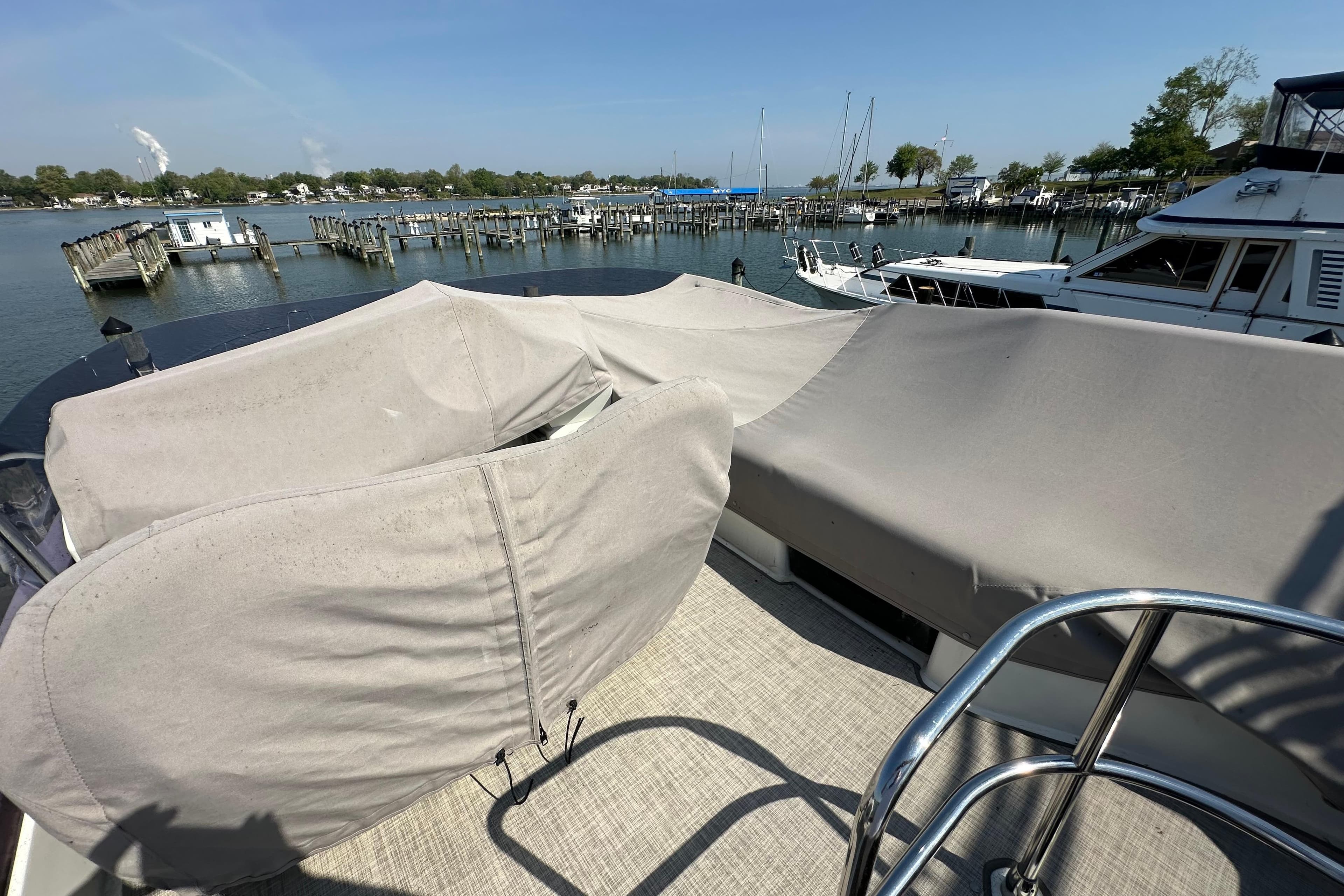 2011 Beneteau Monte Carlo 47 Fly yacht with covered seating, docked at a marina.