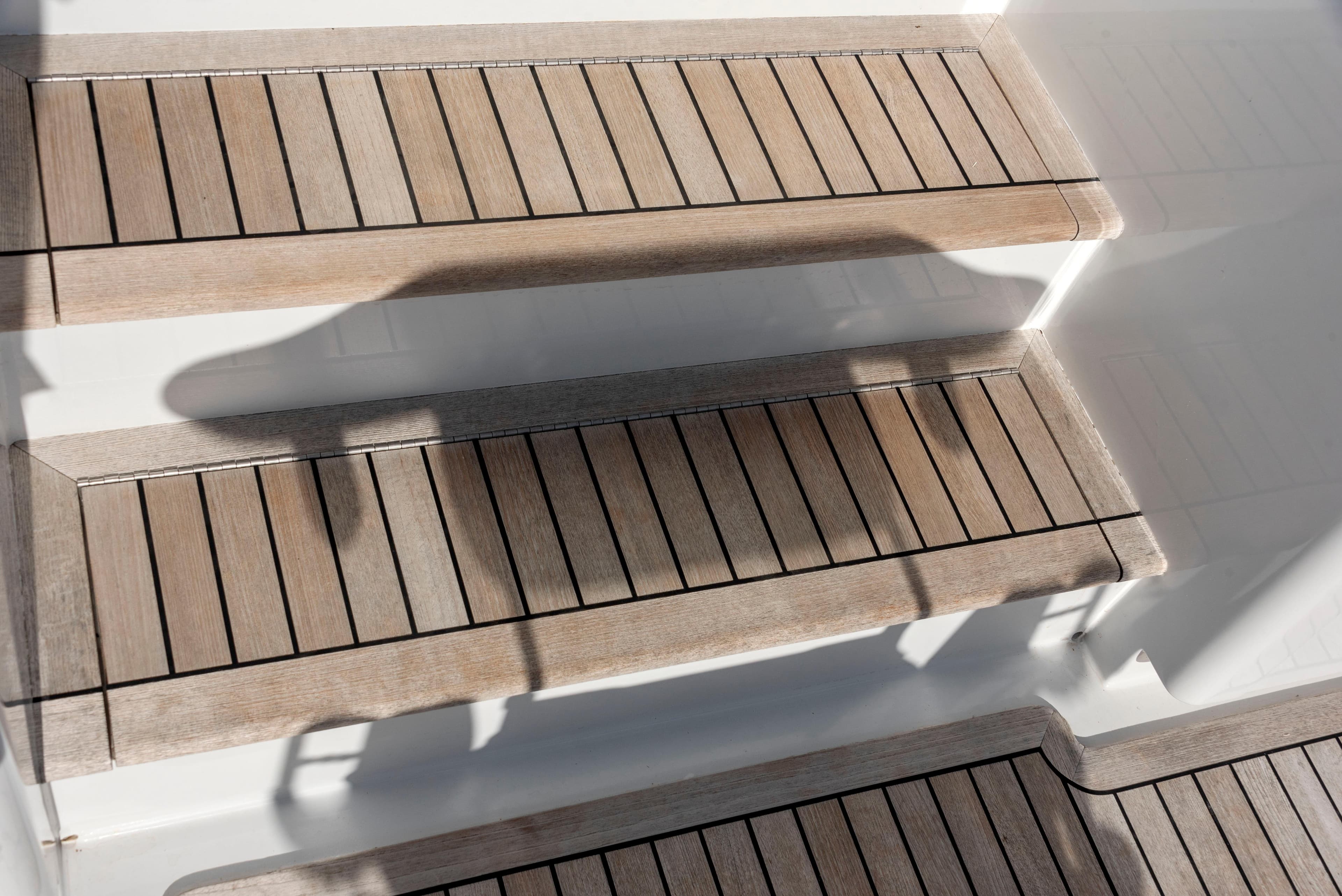 Wooden steps on a 1963 Whiticar 54 Sportfisherman boat, showcasing classic design.