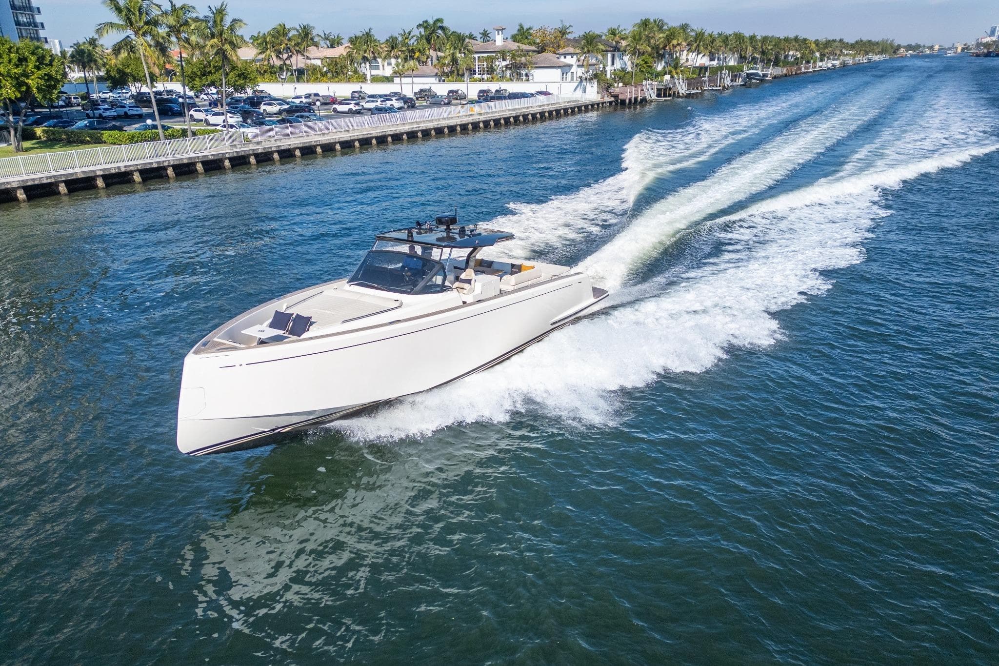 2019 Pardo Yachts P50 cruising on a sunny waterway, surrounded by palm trees.