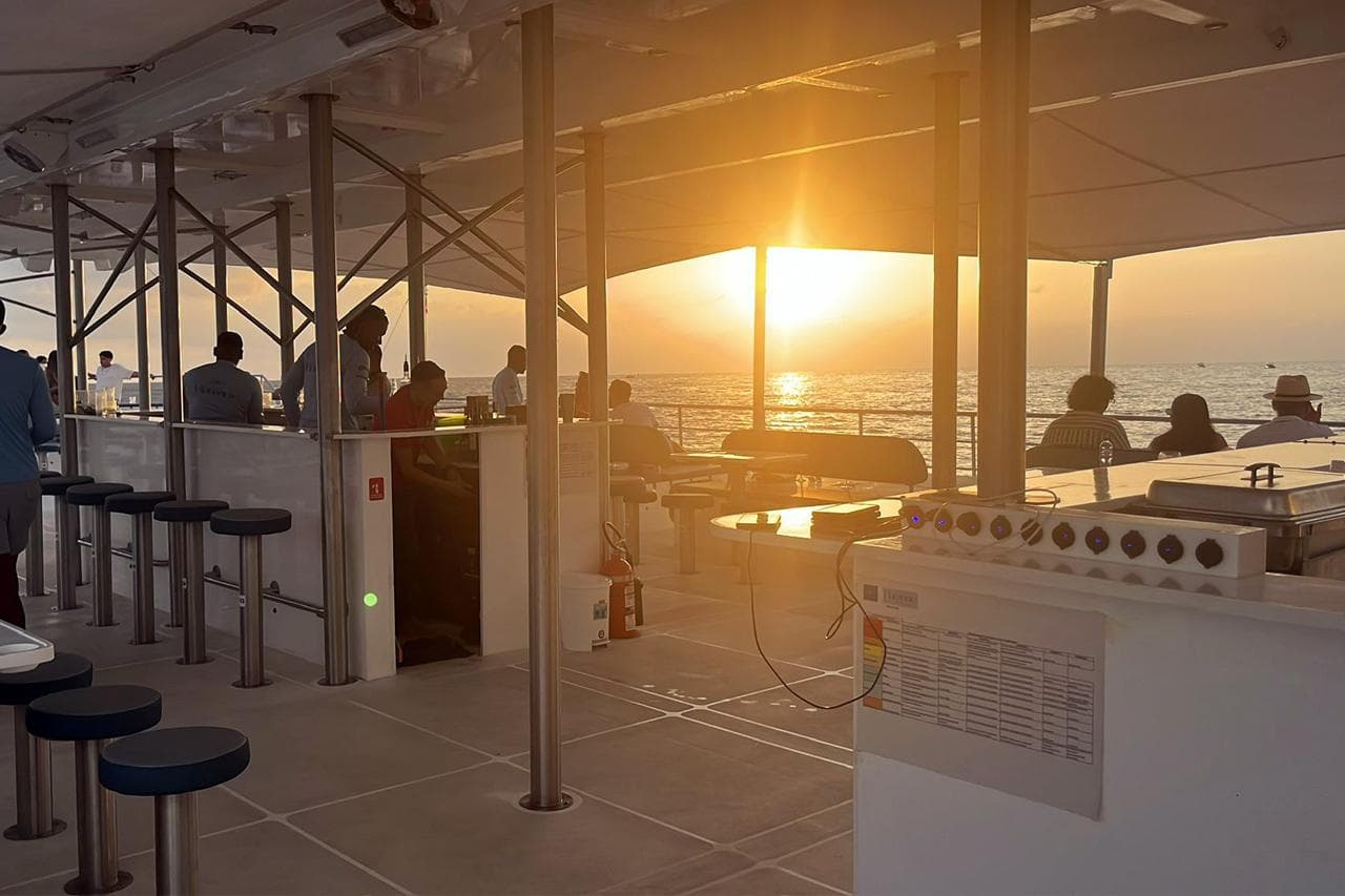 Sunset view from Custom PaxCat 80 yacht deck, 2024 model, with passengers enjoying the scenery.