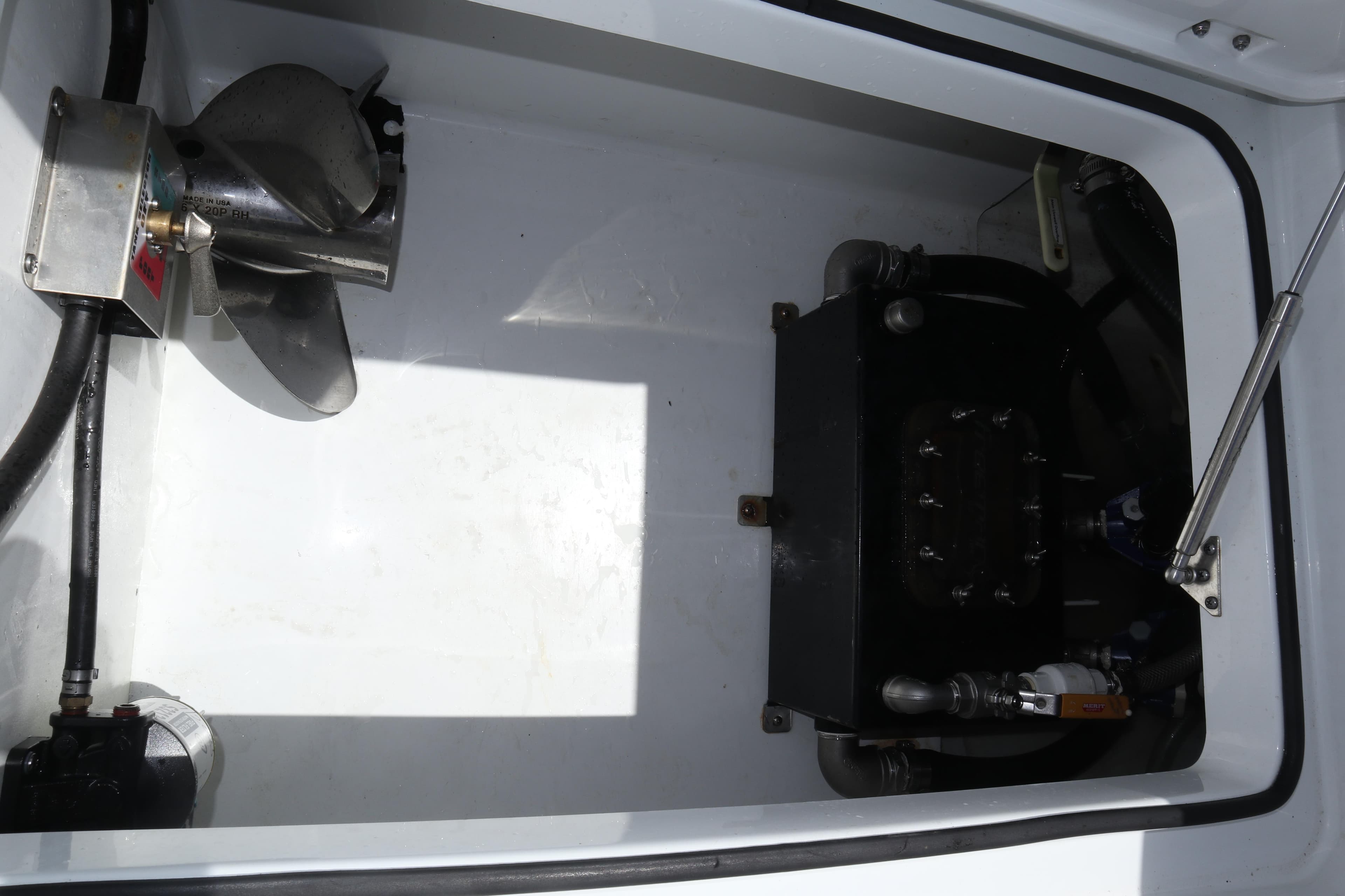 Engine compartment of a 2022 Freeman 34VH boat, featuring mechanical components and hydraulic systems.