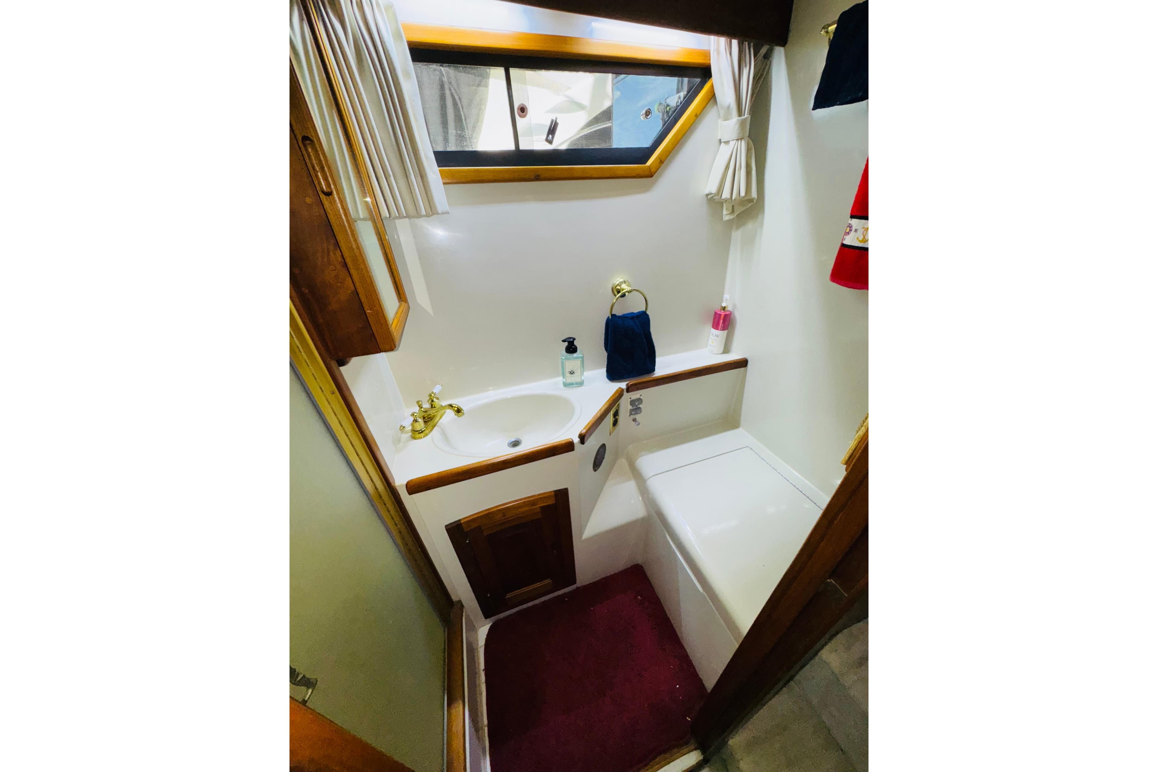 Bathroom interior of 1986 Californian 48 Motor Yacht with sink and window.
