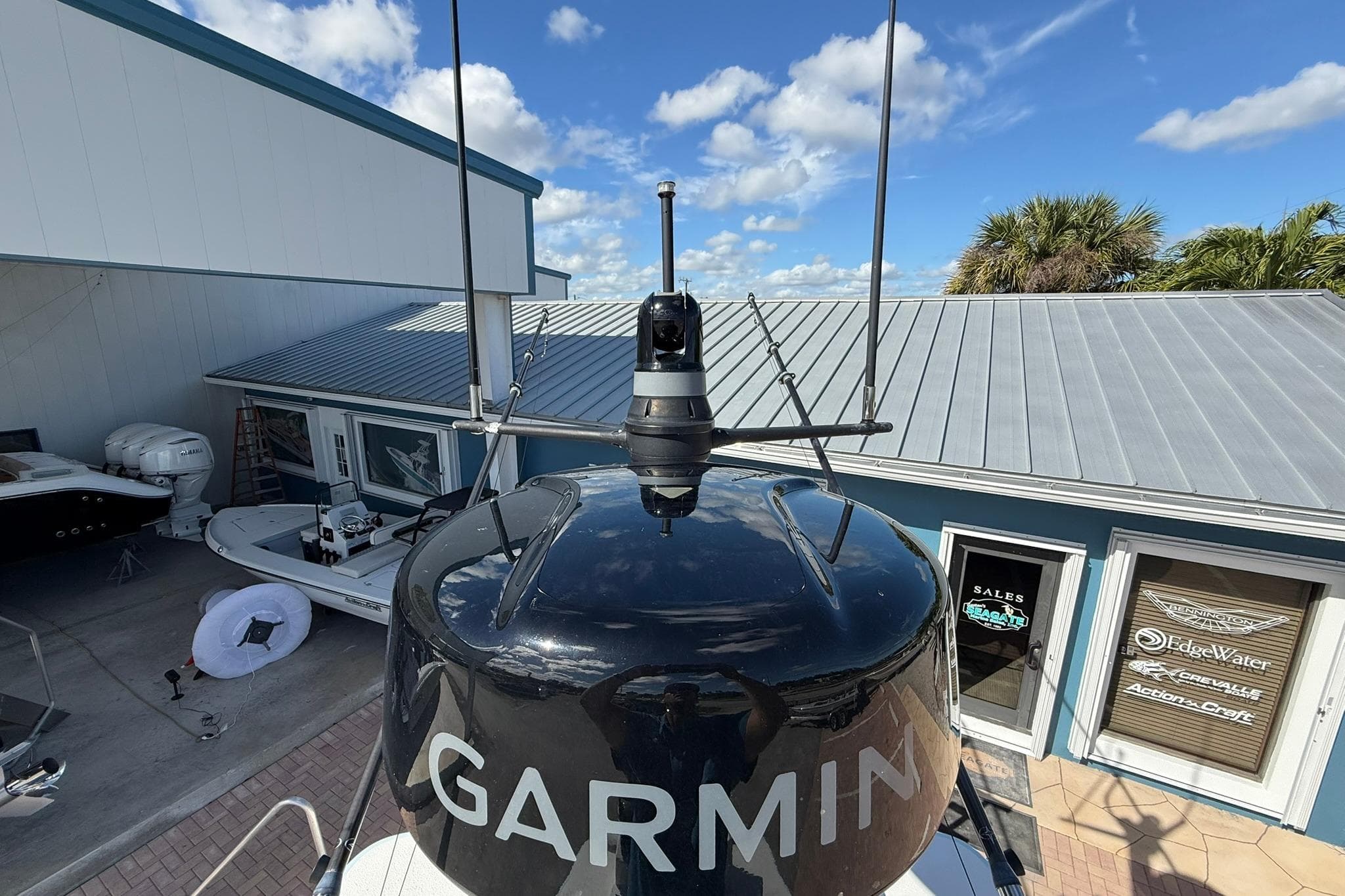 2023 Caymas 28 HB Twin boat with Garmin radar, docked near a sales office.