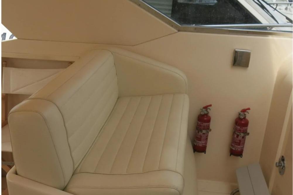 Cream leather seating and fire extinguishers on a 1989 Riva TROPICANA 43 yacht interior.