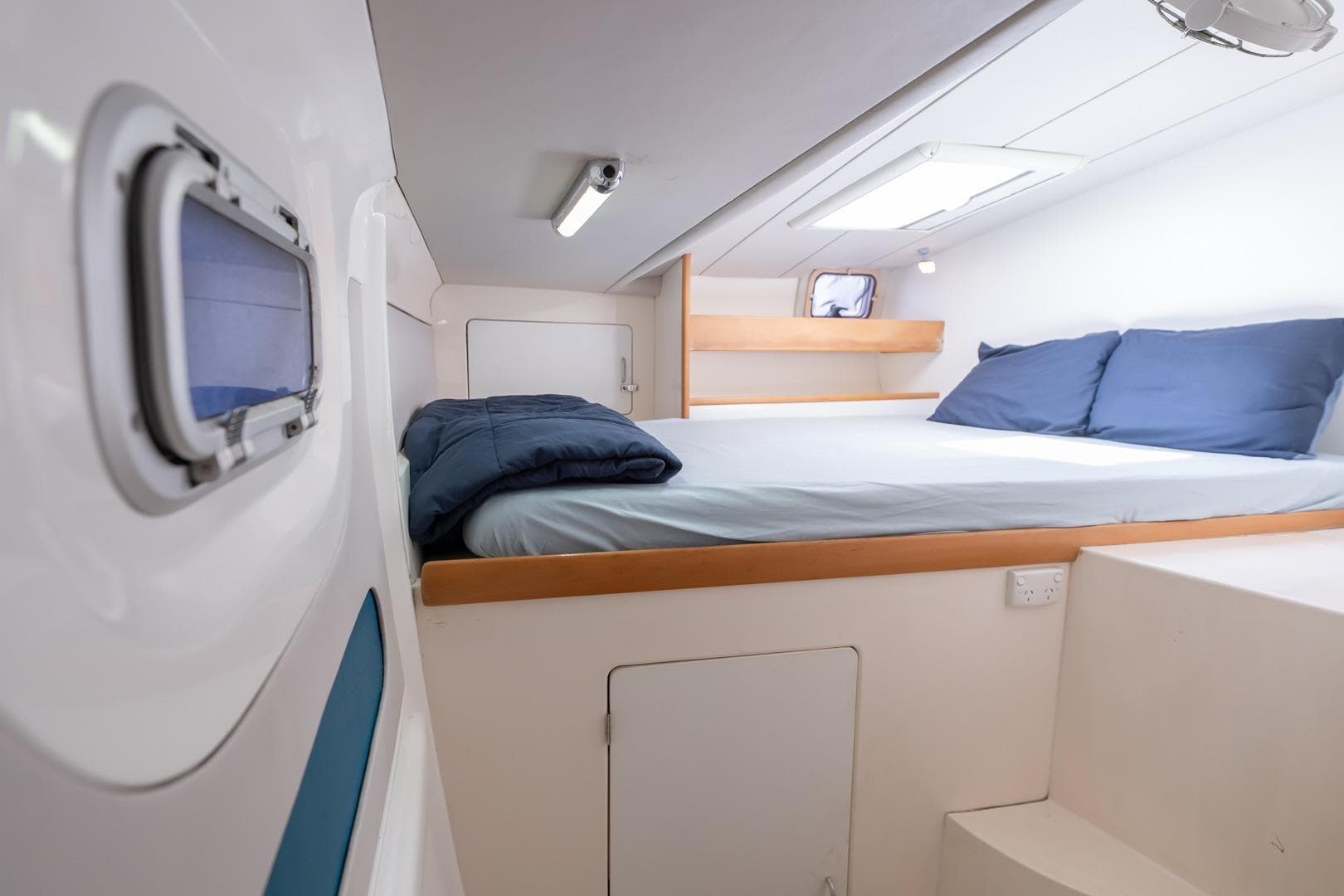 Cozy cabin interior of a 2000 Leopard 38 catamaran with a comfortable bed.