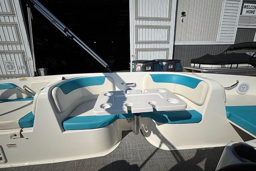 2022 Bayliner Element E18 boat interior with blue seating and a central table.