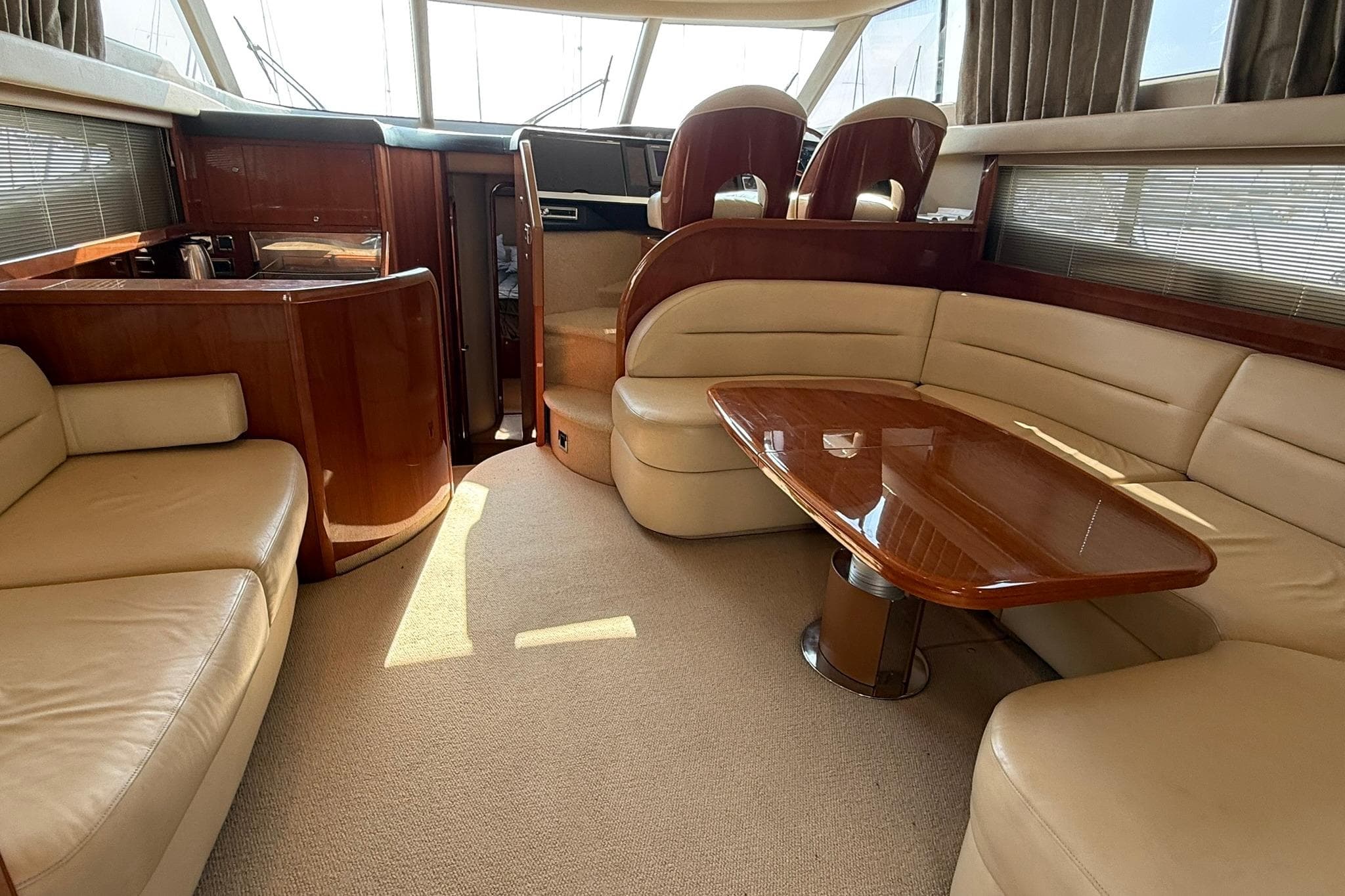 Luxurious interior of a 2007 Princess 50 yacht with leather seating and wooden table.