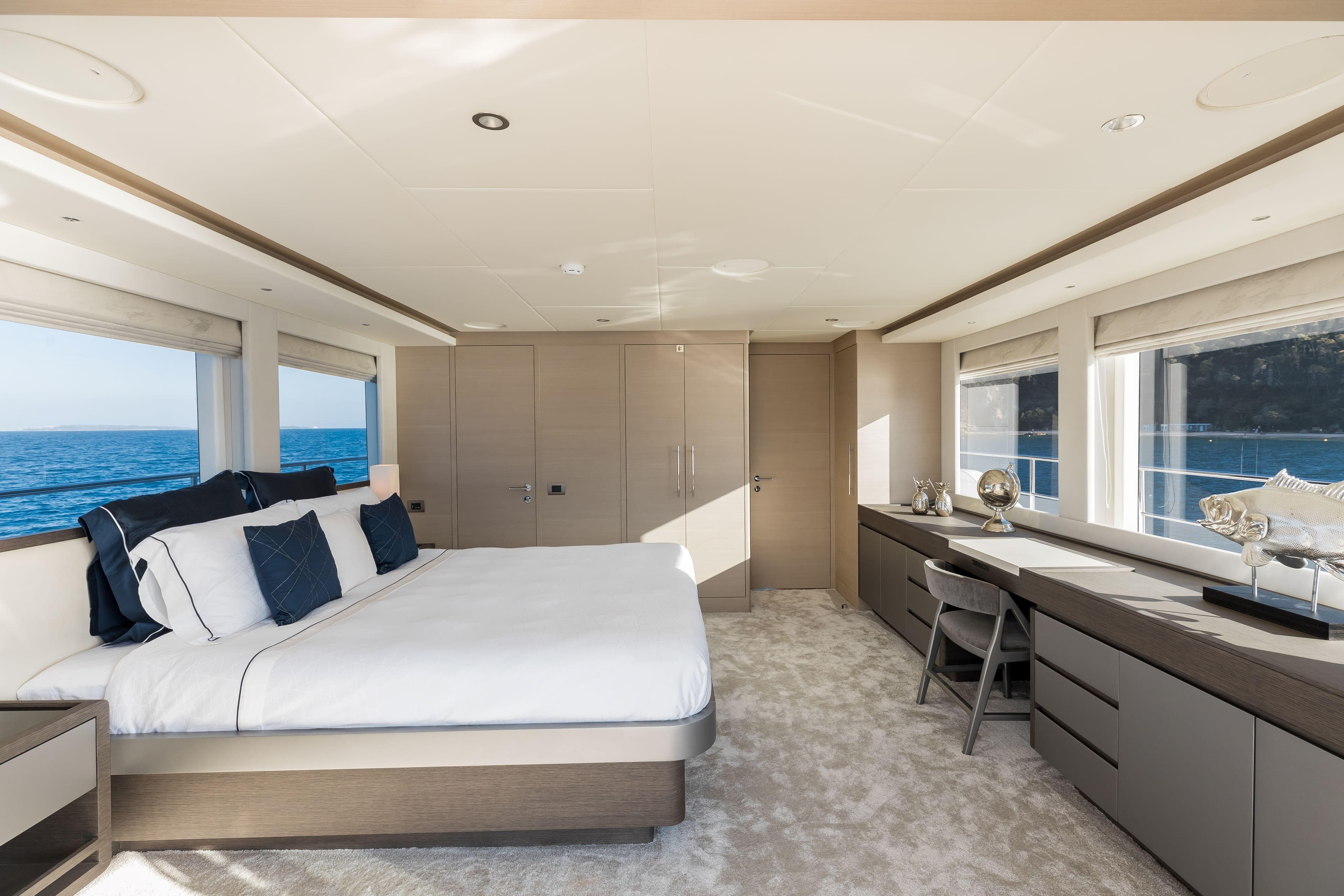 Luxurious bedroom interior on 2025 Nomad 95 SUV yacht with ocean view.