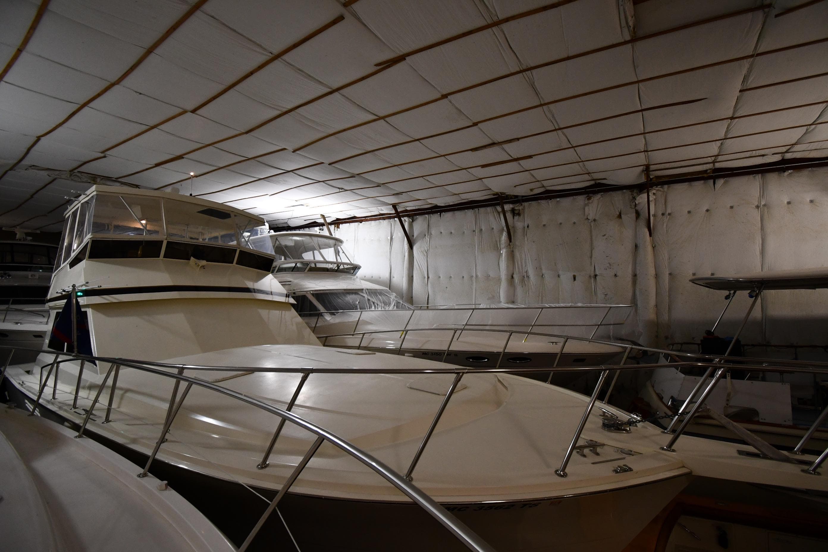1988 Viking 48 Convertible yacht stored indoors, surrounded by other boats.