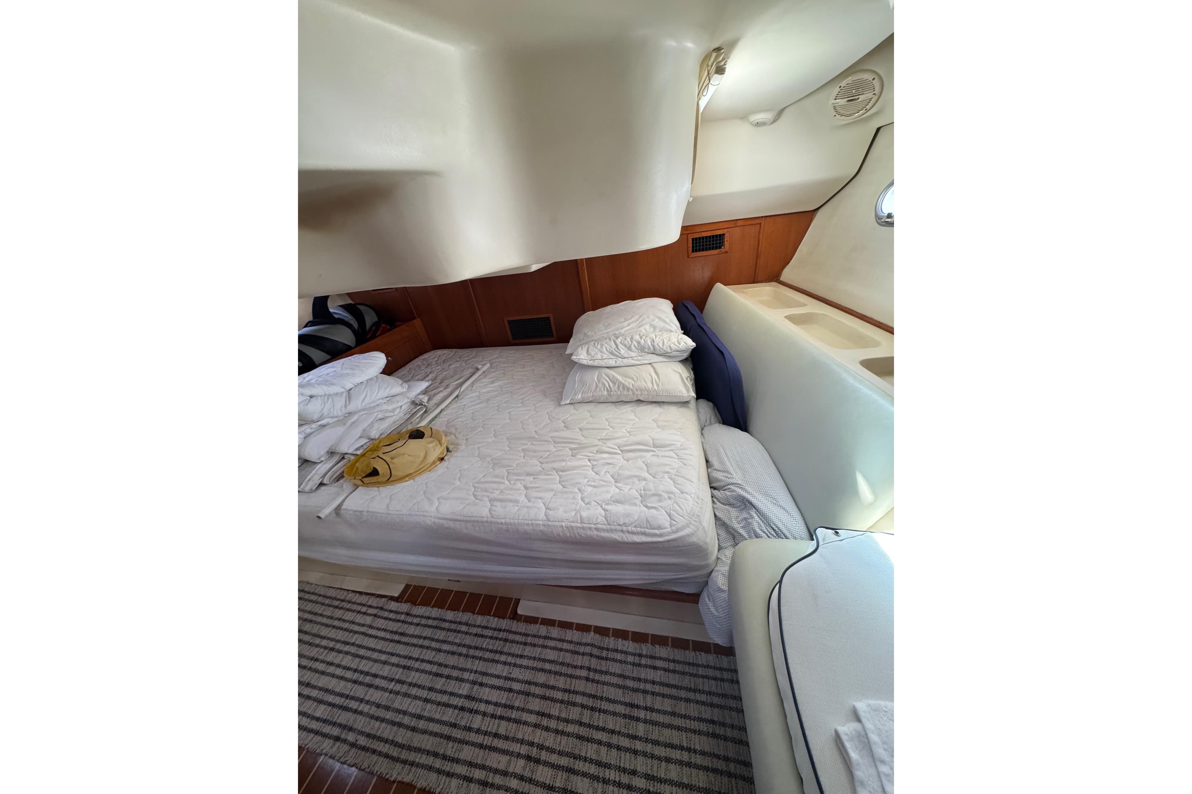 Cozy cabin interior of 2002 Hunter 410 sailboat with bed and wooden accents.
