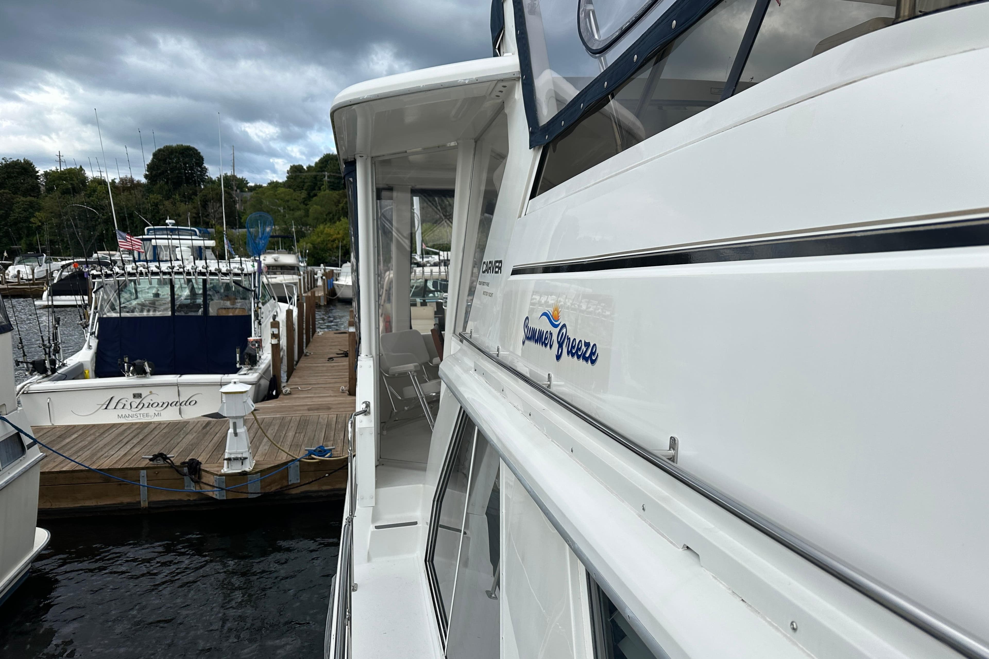 1998 Carver 445 Aft Cabin Motor Yacht docked at marina under cloudy sky.