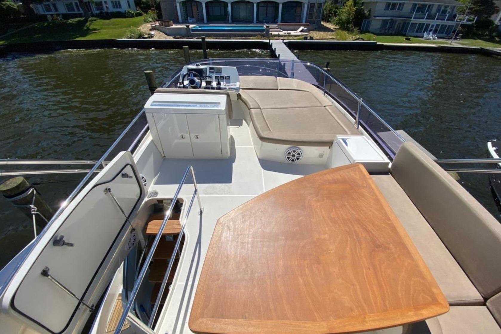 Flybridge of 2012 Prestige 500 yacht with seating, table, and helm station.