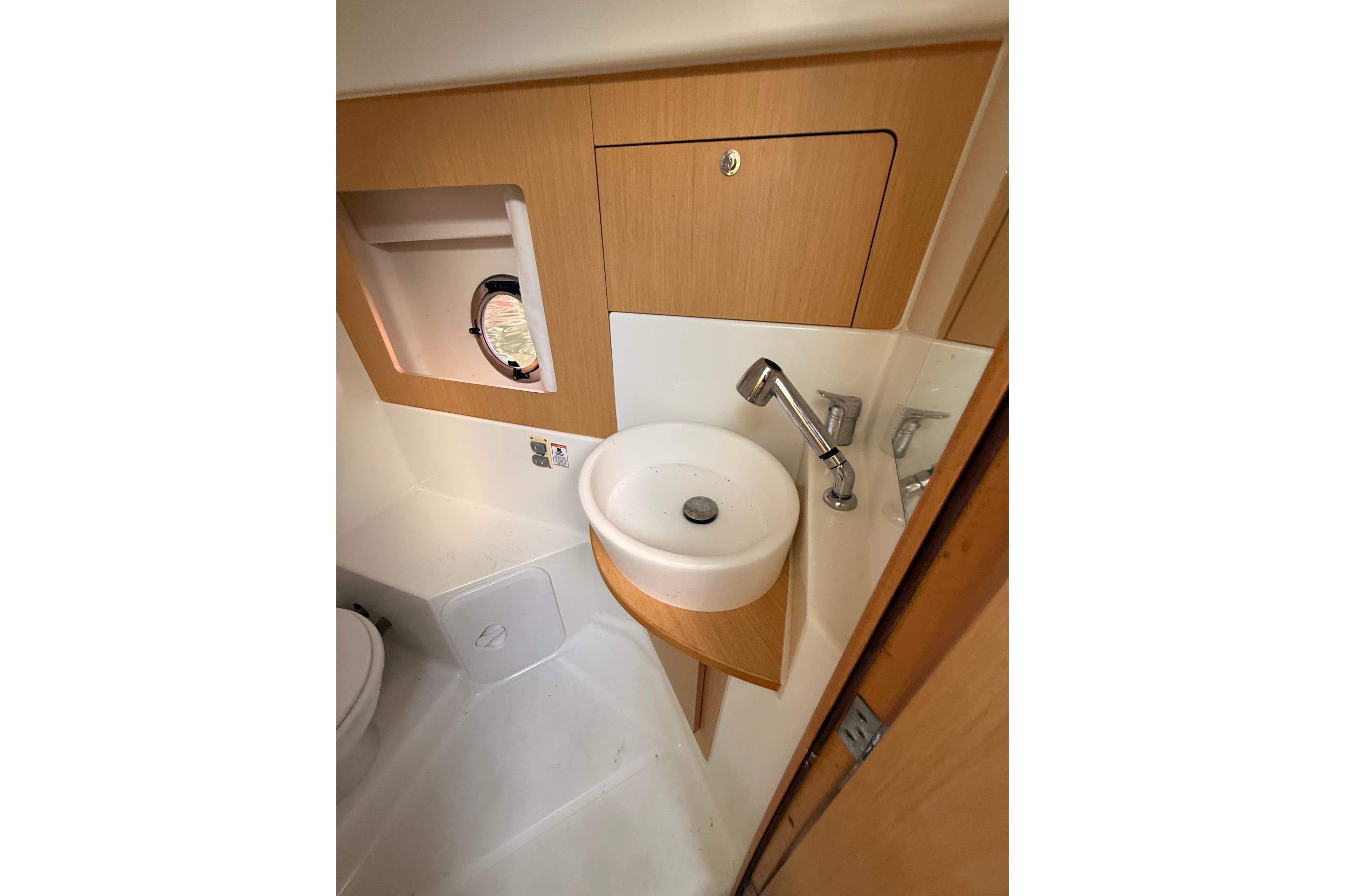 2013 Beneteau Flyer GT 34 bathroom with sink, faucet, and porthole window.