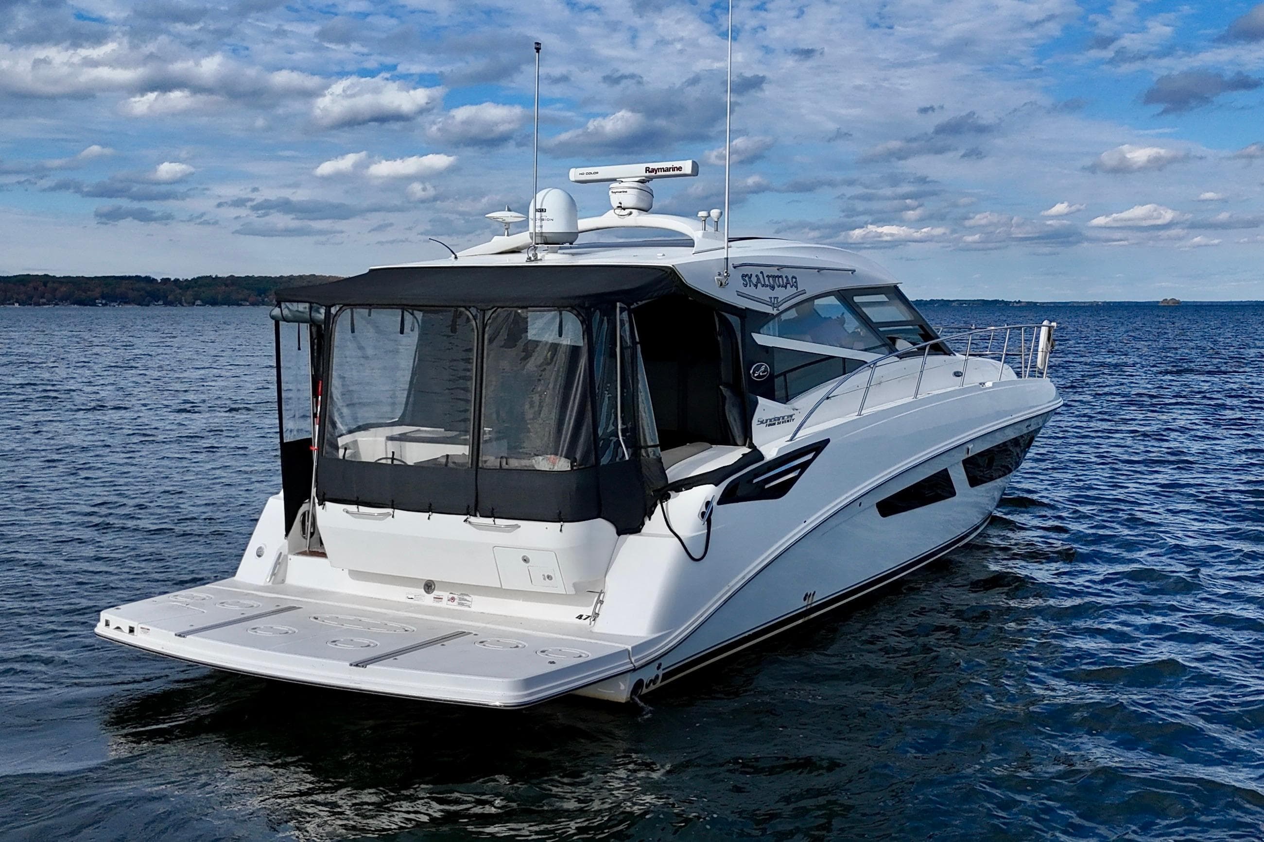 2015 Sea Ray 470 Sundancer yacht on calm water under a partly cloudy sky.