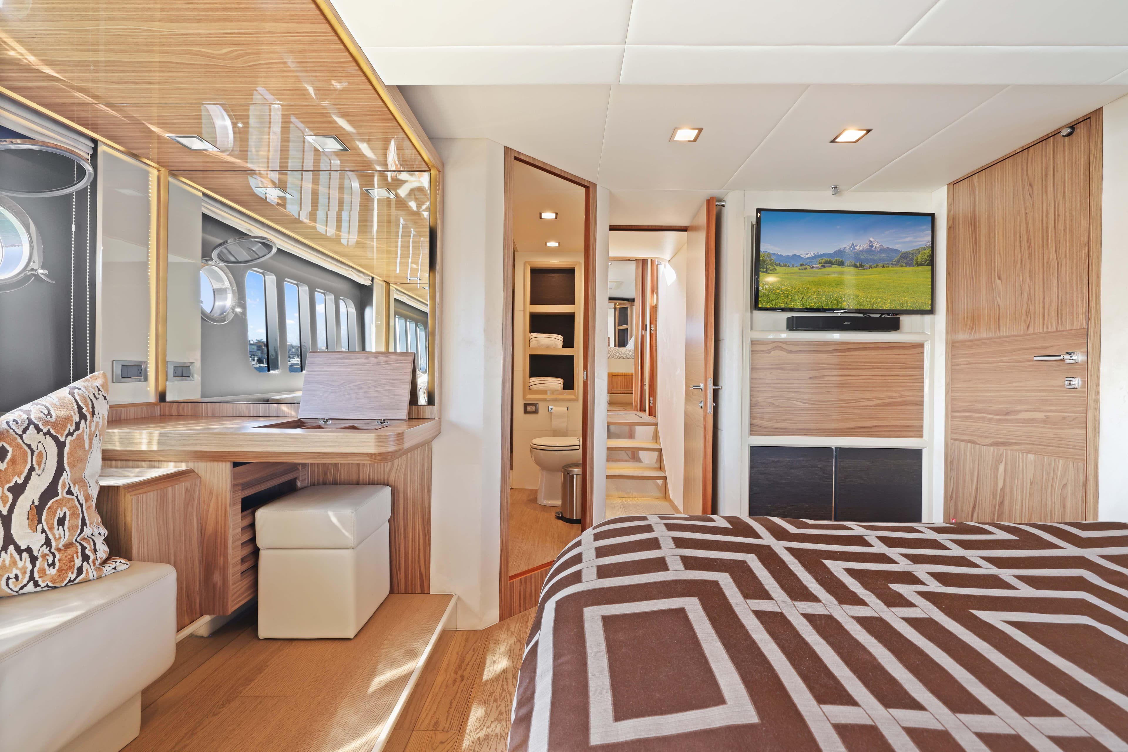 Luxurious yacht interior with modern design, featuring a cozy bedroom and elegant wooden finishes.