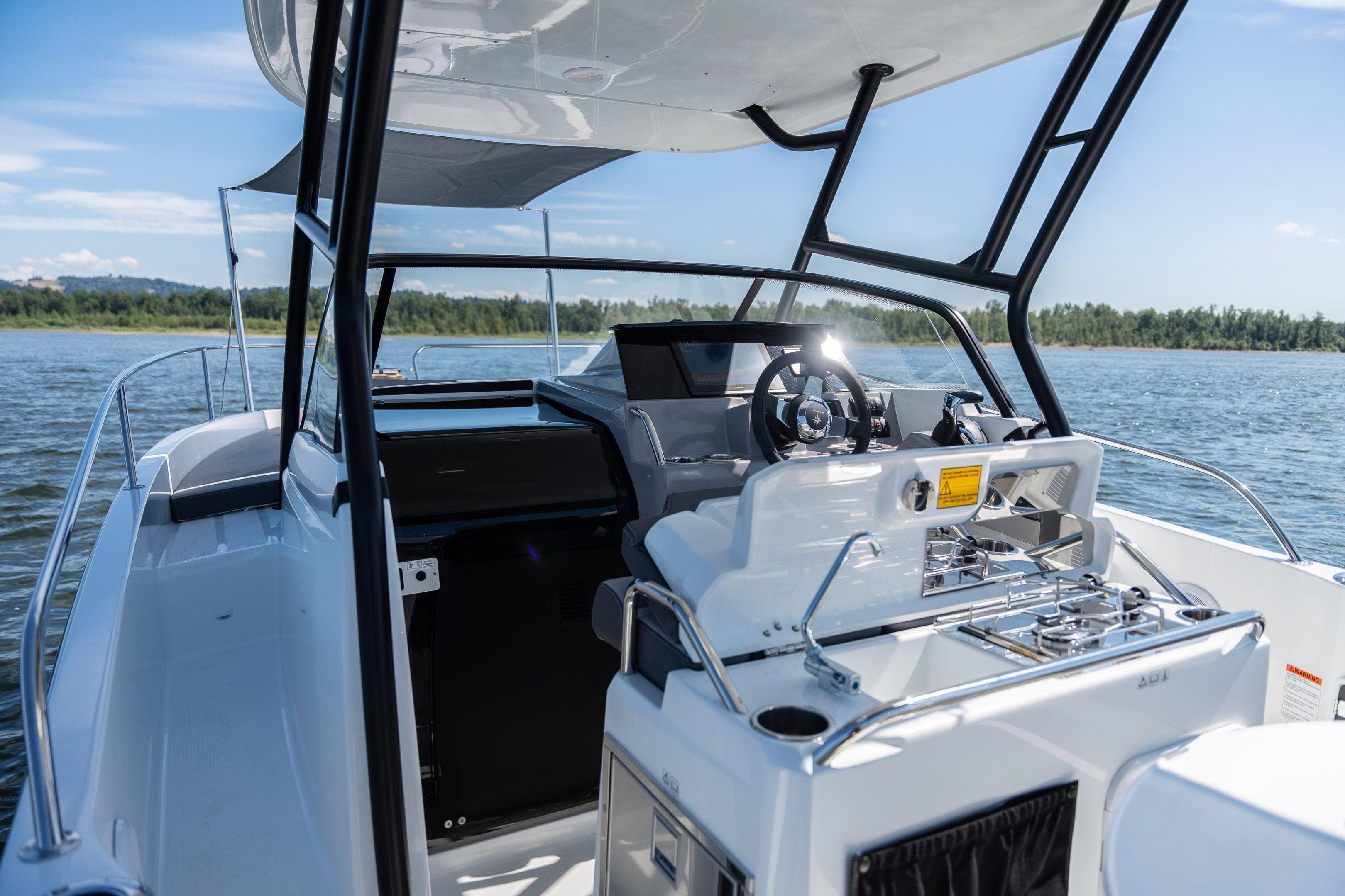 2026 Jeanneau Leader 7.5 WA Series 3 boat interior with steering wheel and outdoor kitchen.