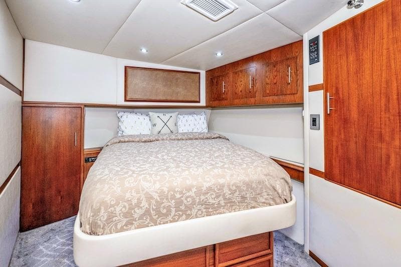 Luxurious bedroom interior of 1991 Ocean Yachts 53 Super Sport with elegant wood cabinetry.