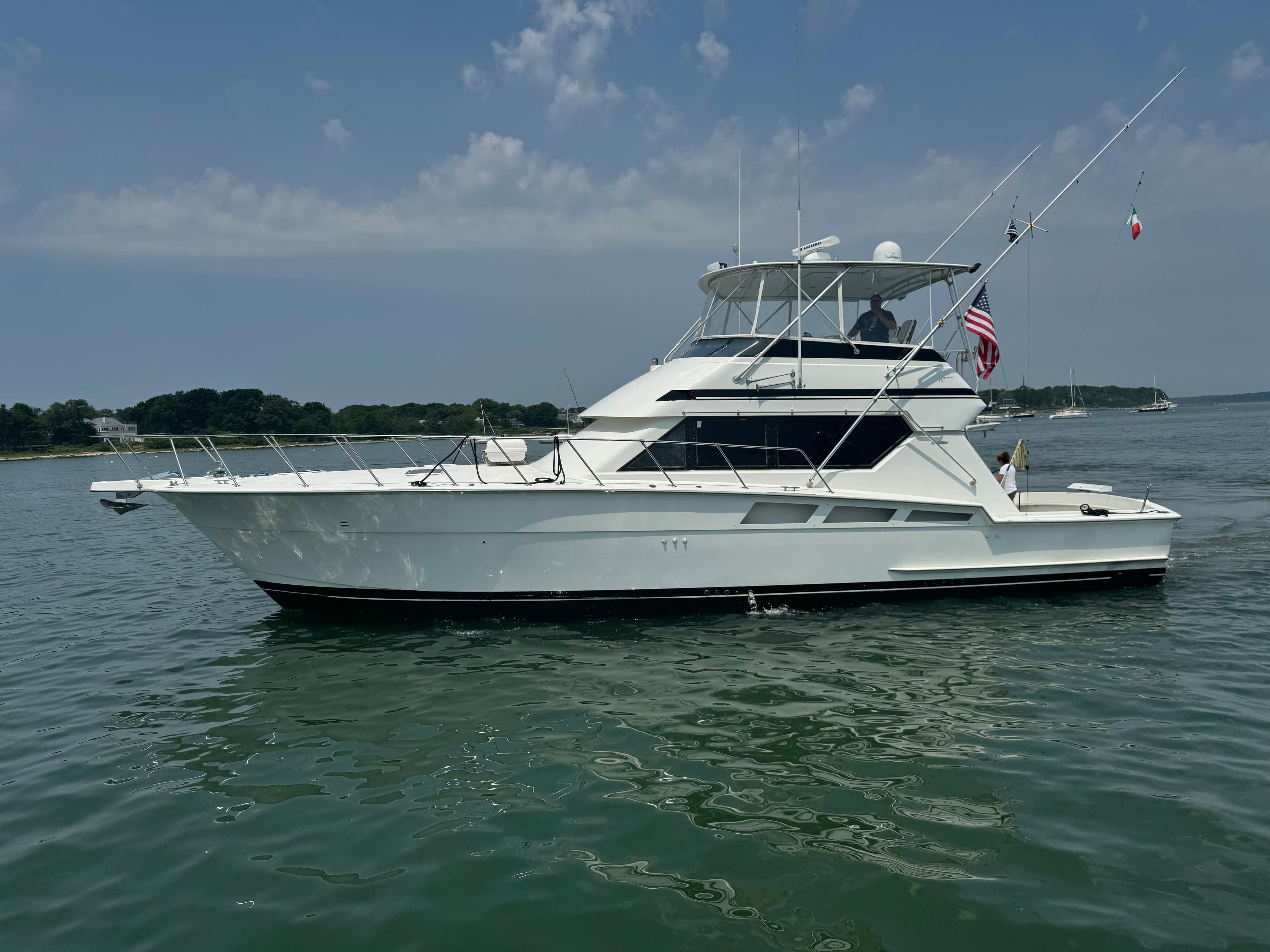 1994 Hatteras 54 Convertible yacht on calm water under a clear sky.