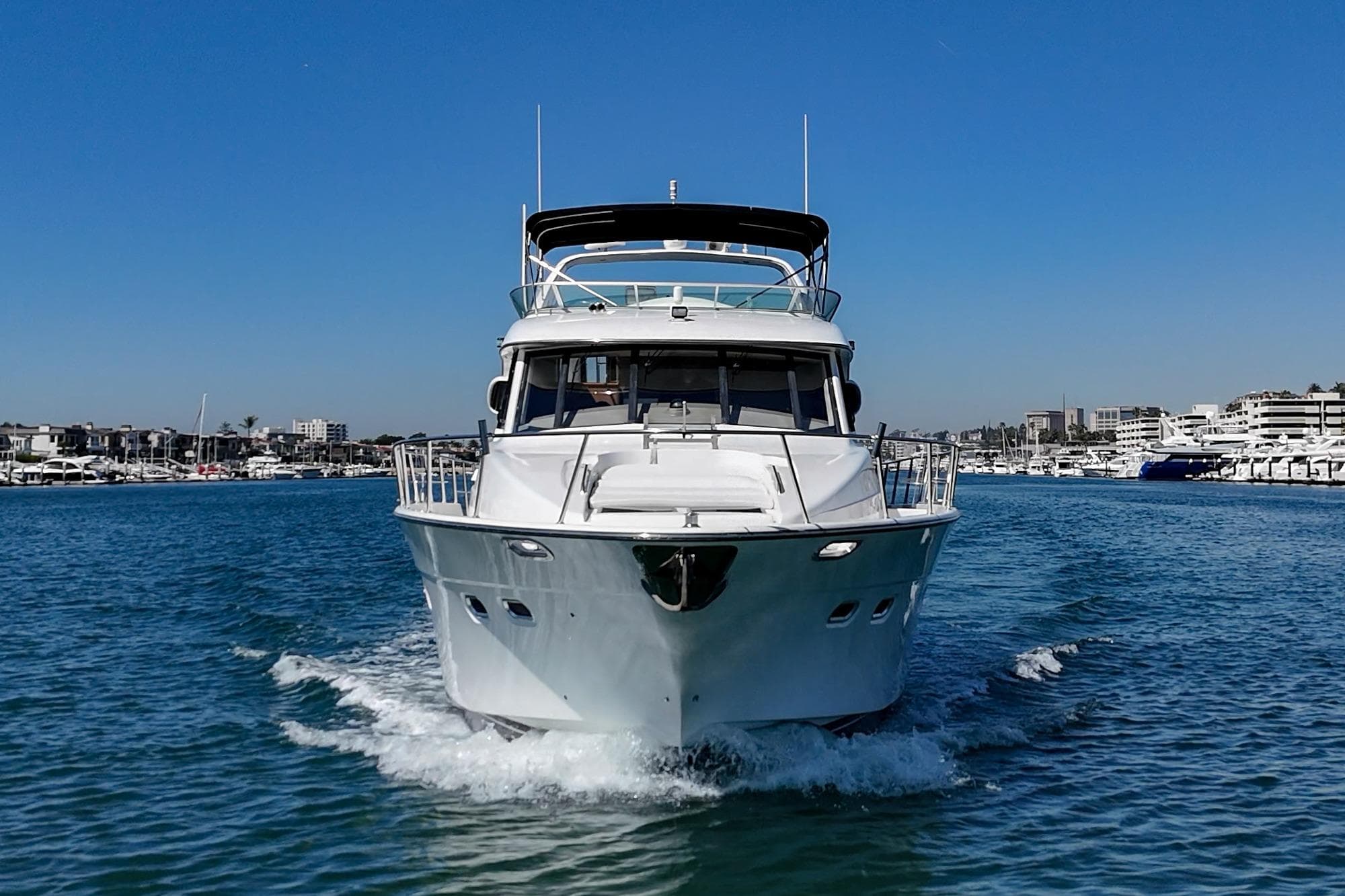 Front view of a 2000 Bayliner 5788 Pilot House Motoryacht cruising in a marina.