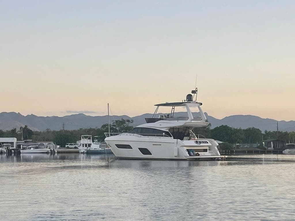 2016 Ferretti Yachts 550 cruising on calm waters at sunset.