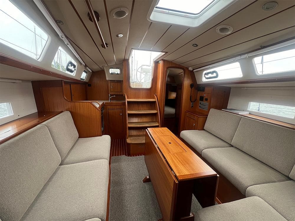 2023 Hallberg-Rassy 340 yacht interior with wooden finish and comfortable seating.