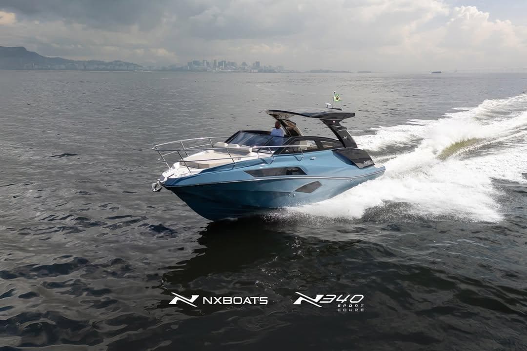 2026 NX Boats NX340 cruising on open water with city skyline in background.