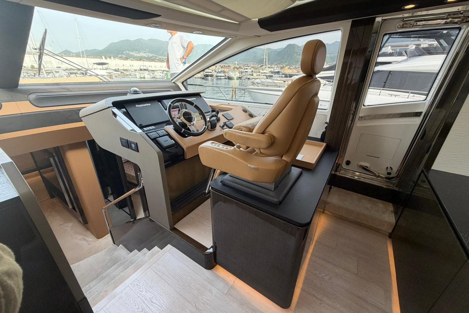 Luxurious helm station of 2016 Azimut 77S yacht with leather captain's chair.