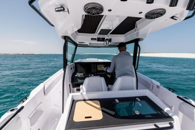 2027 Axopar 29 CCX boat cruising on open water with a person at the helm.