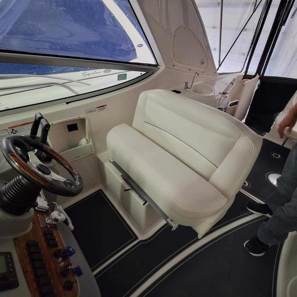 Interior of a 2010 Bayliner 335 boat showing steering wheel and white seating.