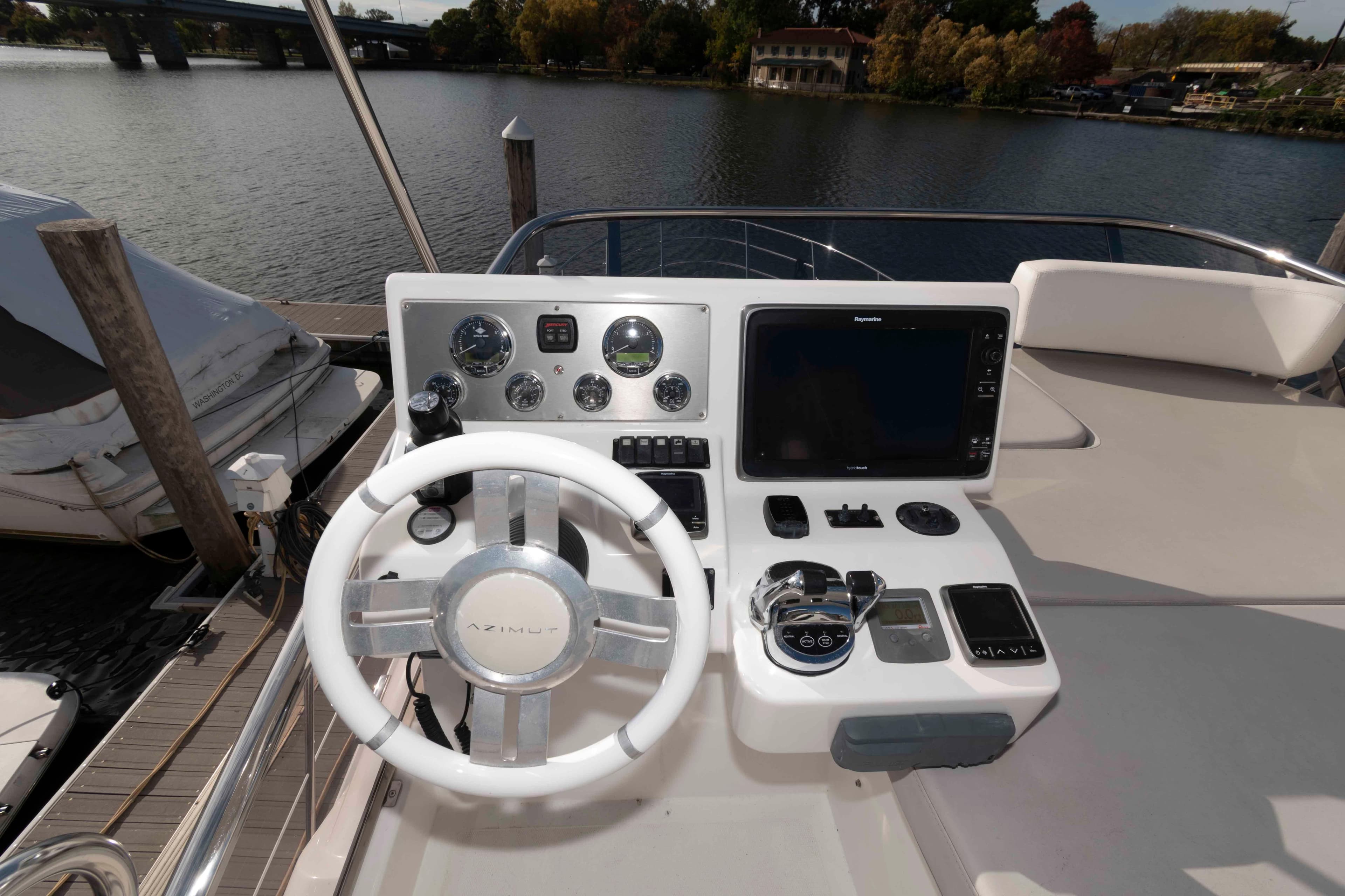 Flybridge helm of 2014 Azimut 45 yacht with steering wheel and navigation controls.