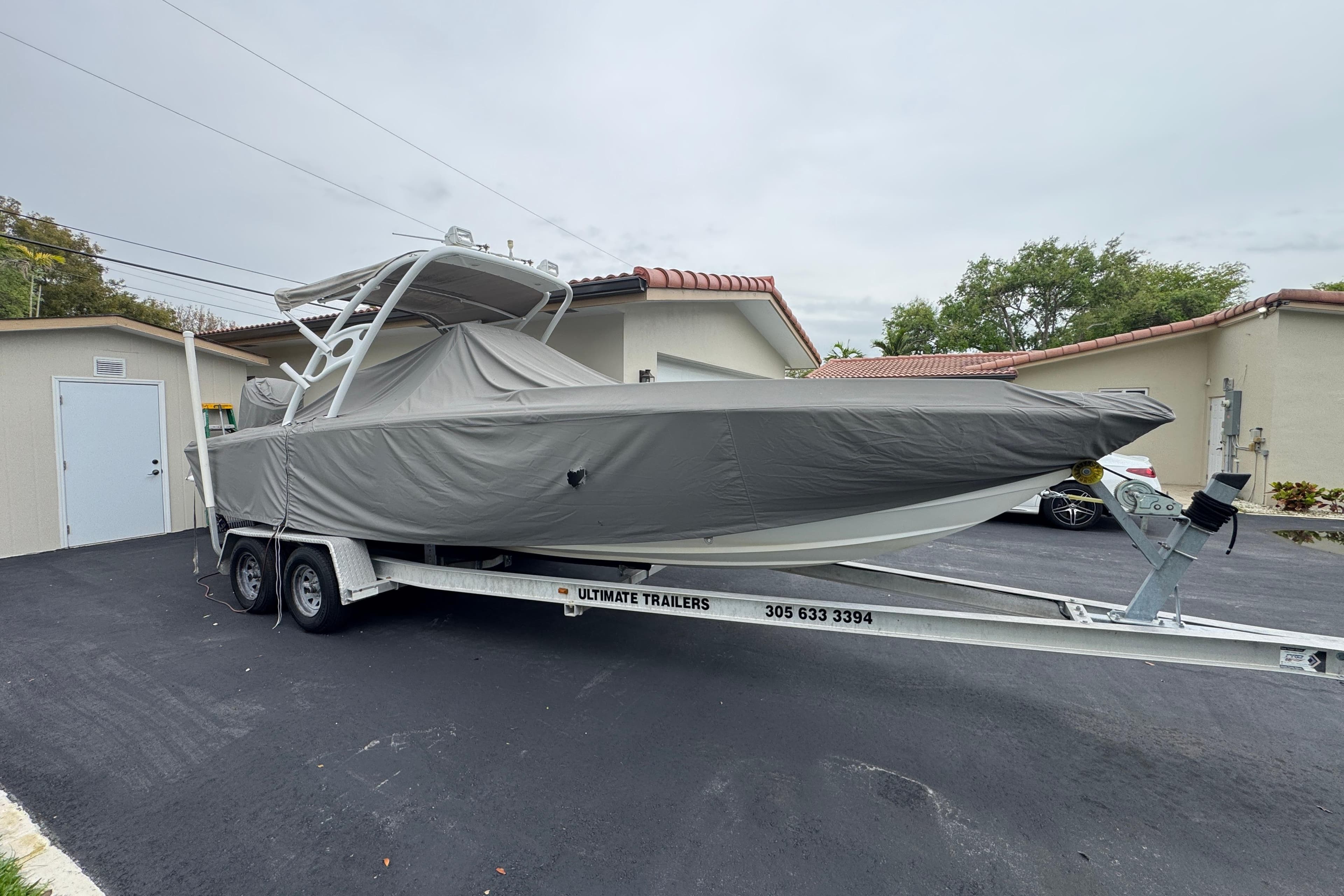 Covered Concept 27 boat on trailer, parked in driveway, 2015 model.