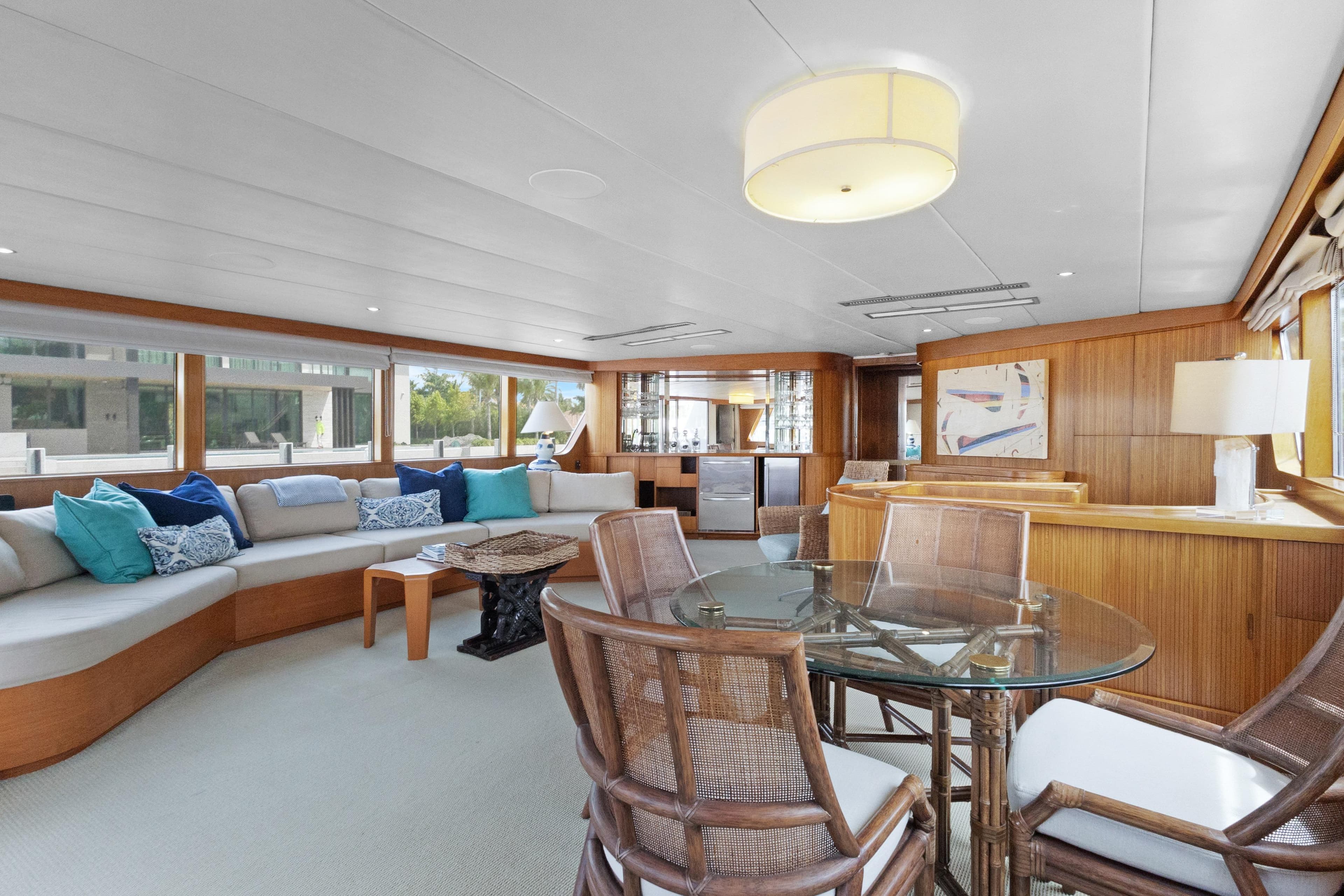 Luxurious 1985 Burger yacht interior with elegant seating, glass table, and modern decor.