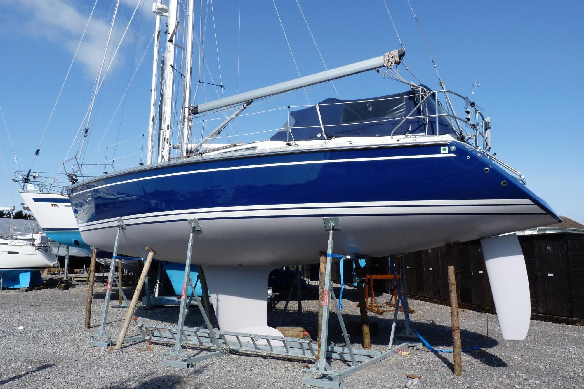 Sailboat on stands, Comfortina 35, 2000 model, blue hull, clear sky background.
